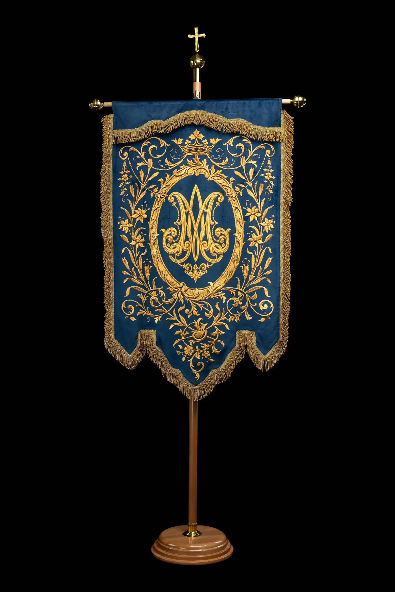 Double-sided blue processional banner with an image of Our Lady of the Immaculate Conception on one side and a Marian monogram on the other, both surrounded by gold floral ornamentation and finished with gold fringes.