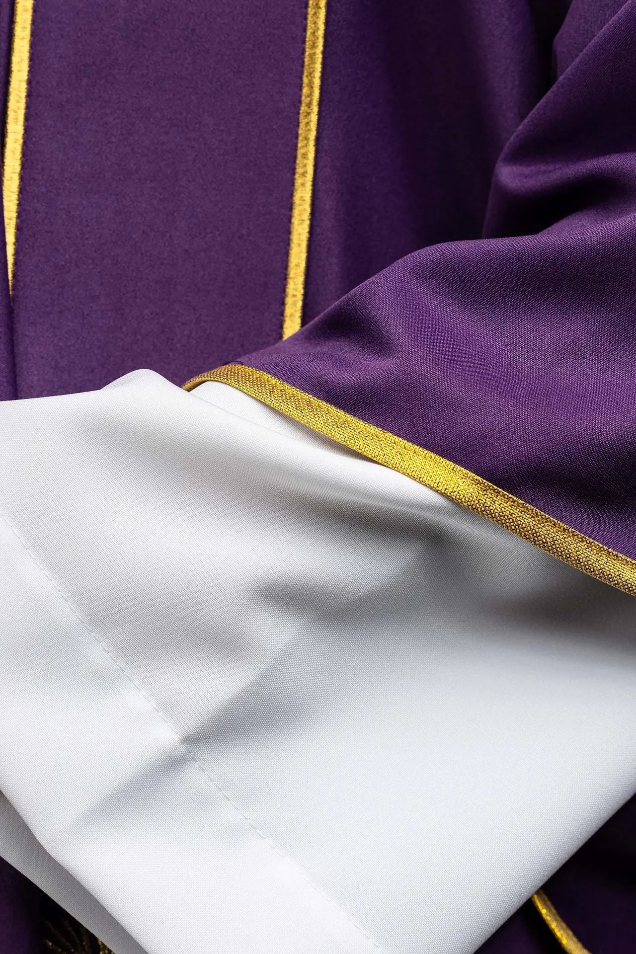 Dalmatica morada con bandas decorativas y bordado de cruz dorada