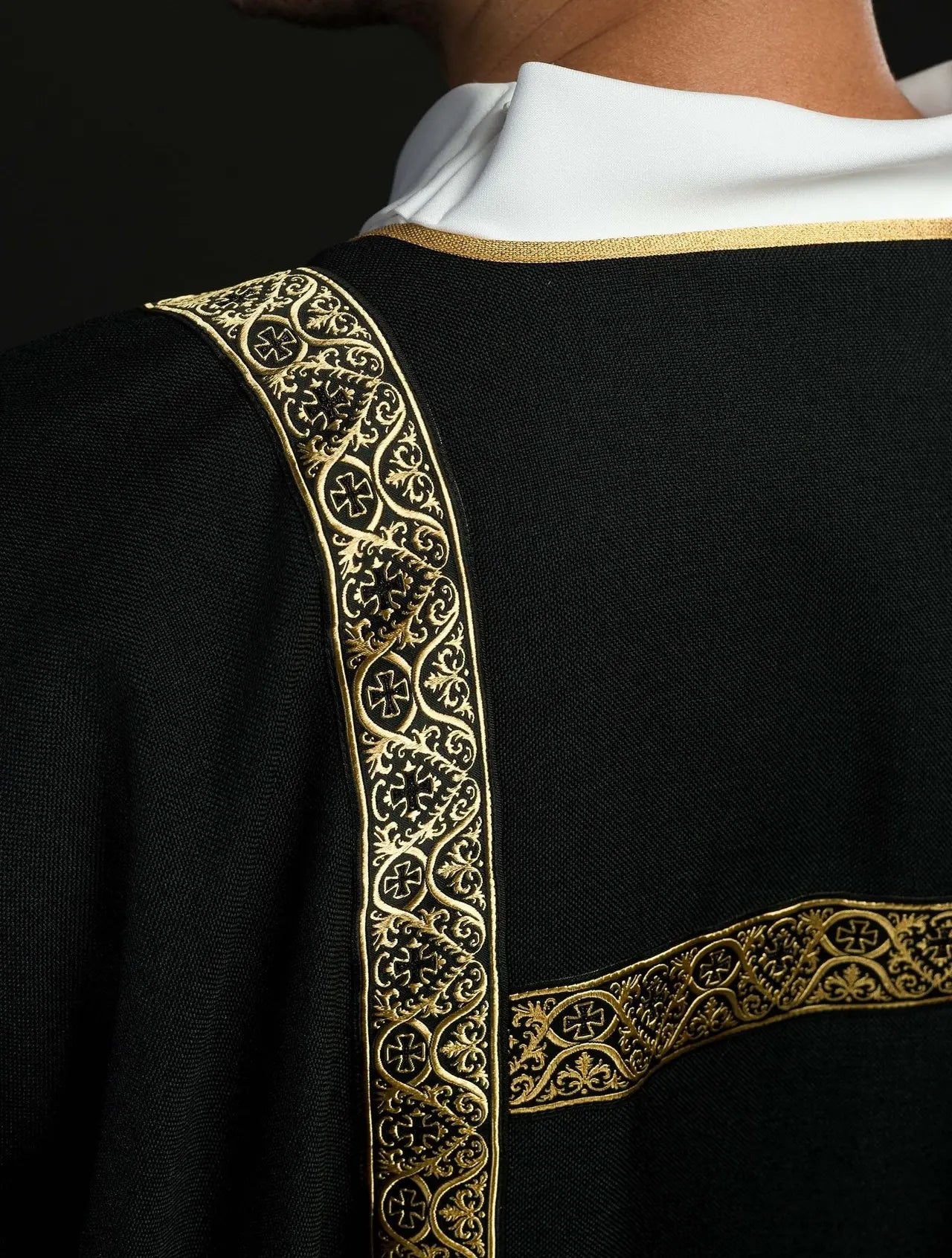 Dalmática negra decorada con cintas de jacquard doradas