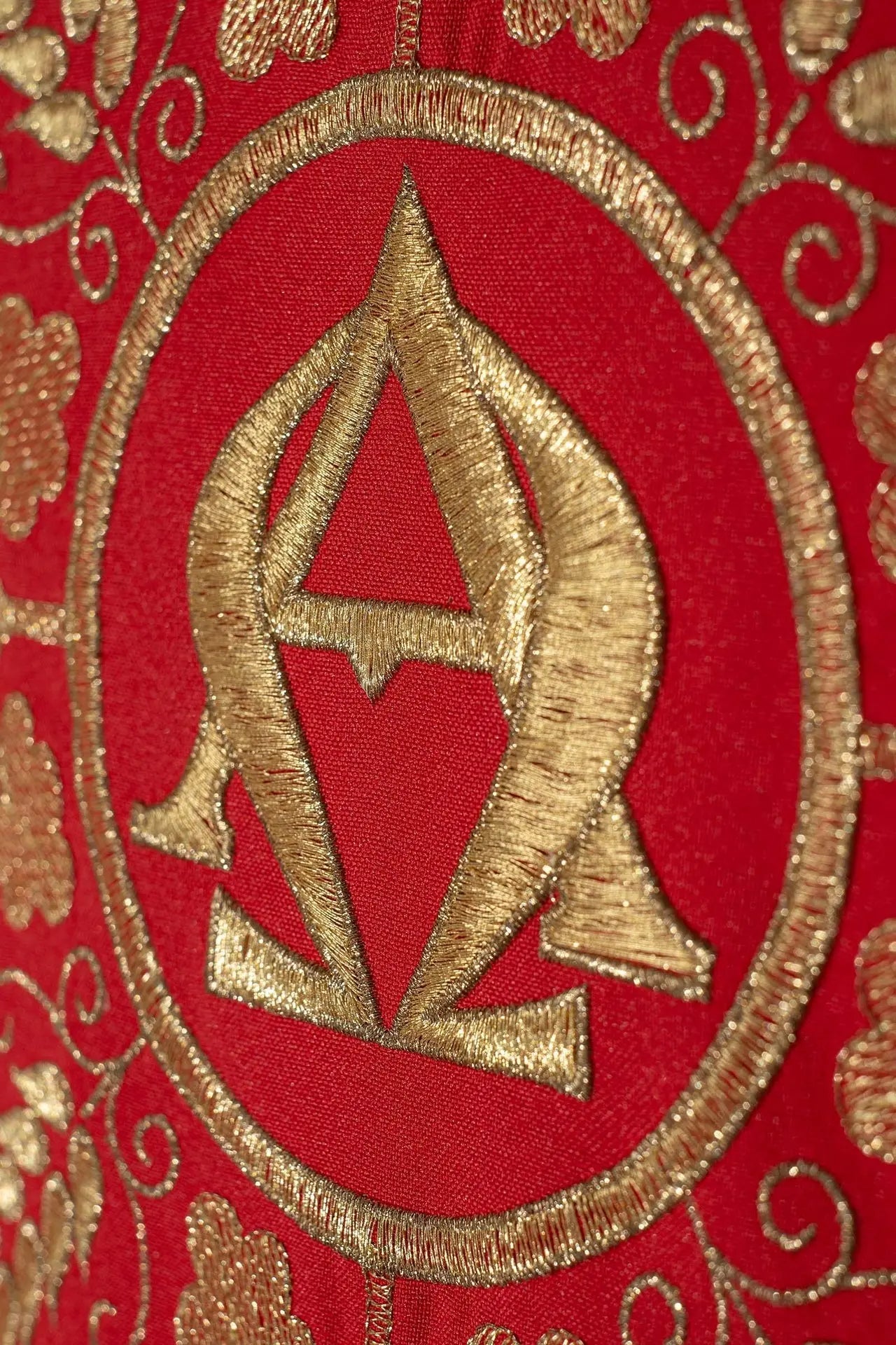Casulla roja bordada con los símbolos Alfa y Omega y espigas de trigo