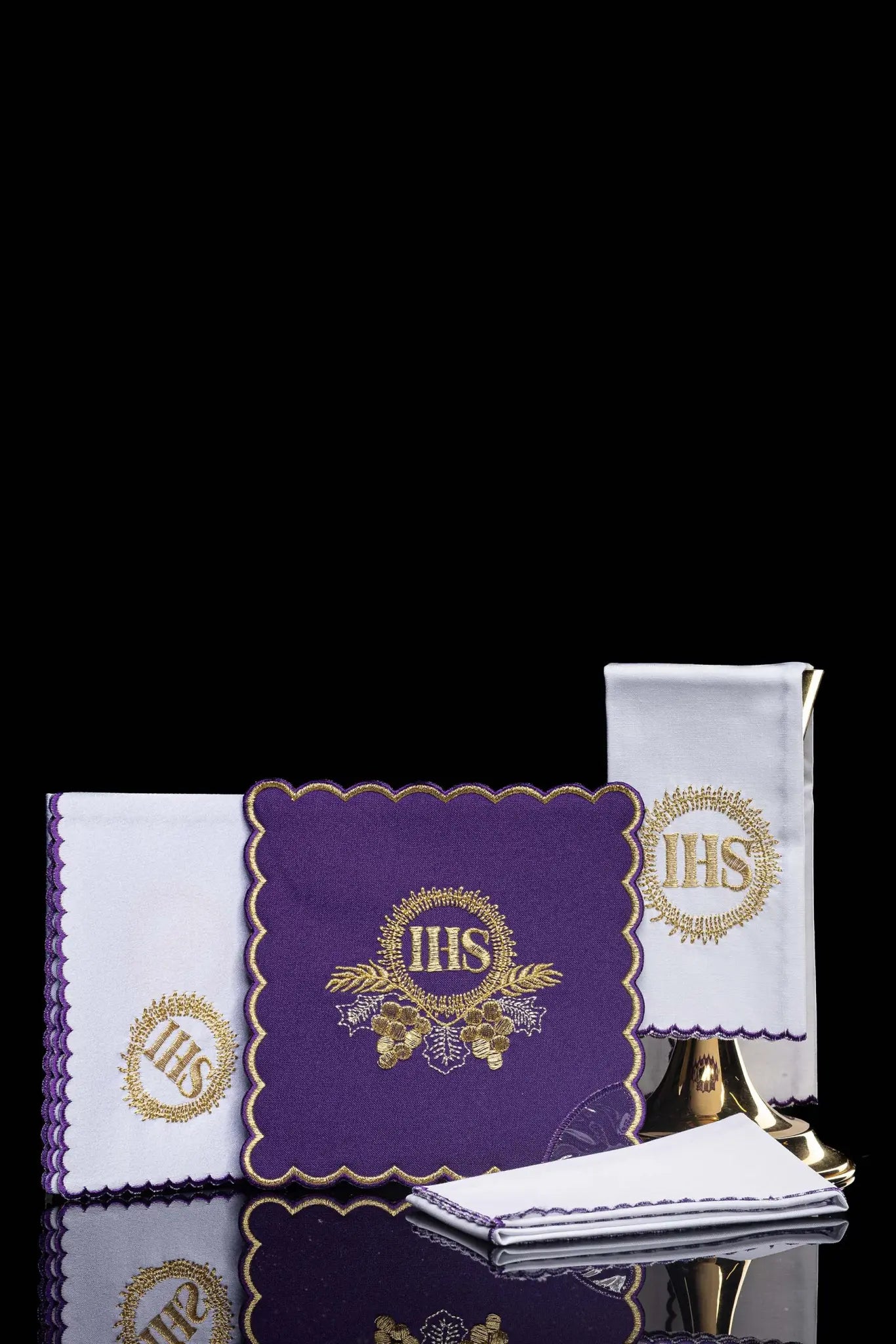 Purple chalice linen set with gold IHS embroidery on pall, corporal, purificator, and lavabo towel