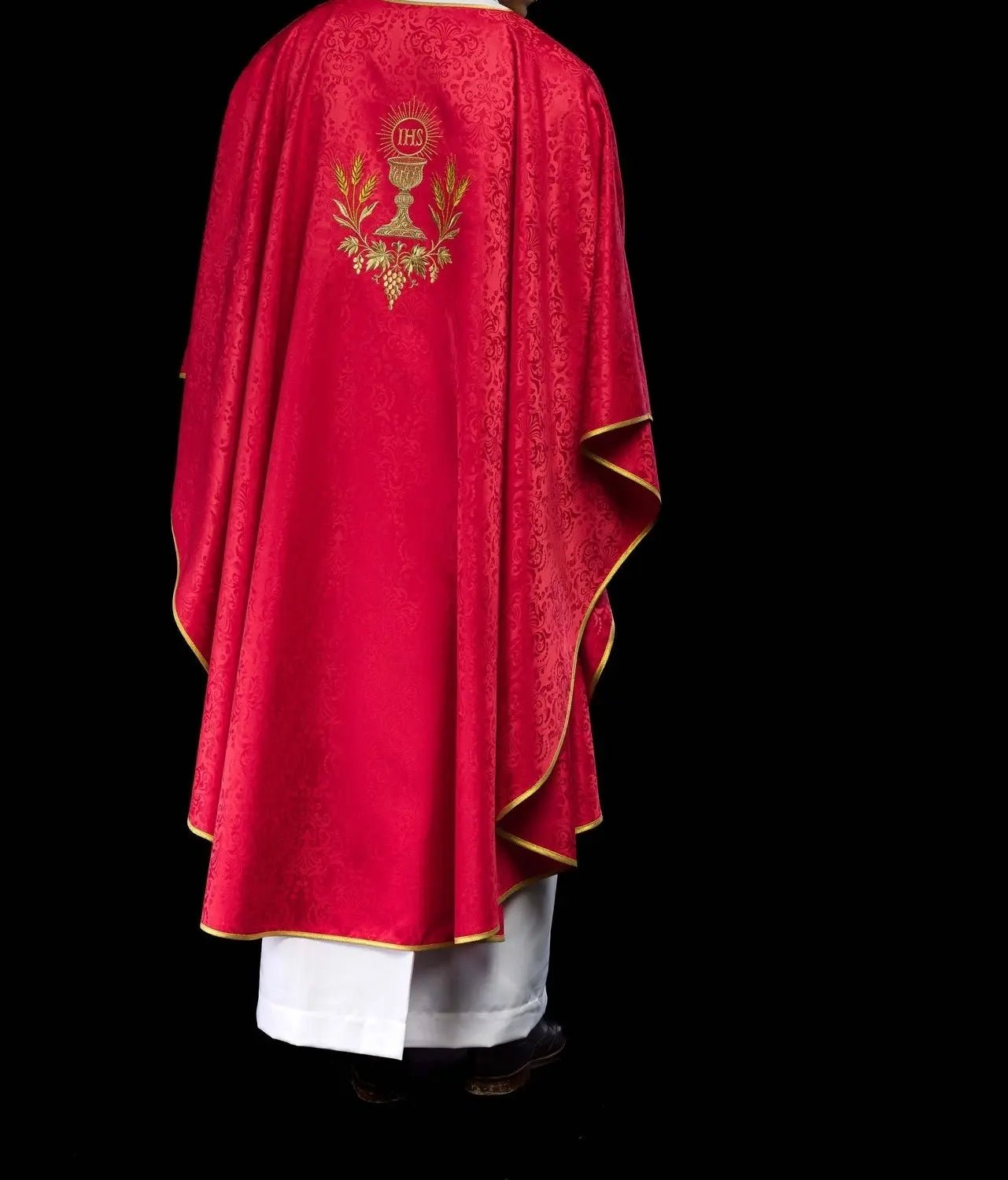 Casulla litúrgica roja con un cáliz bordado y una hostia sobre tela jacquard
