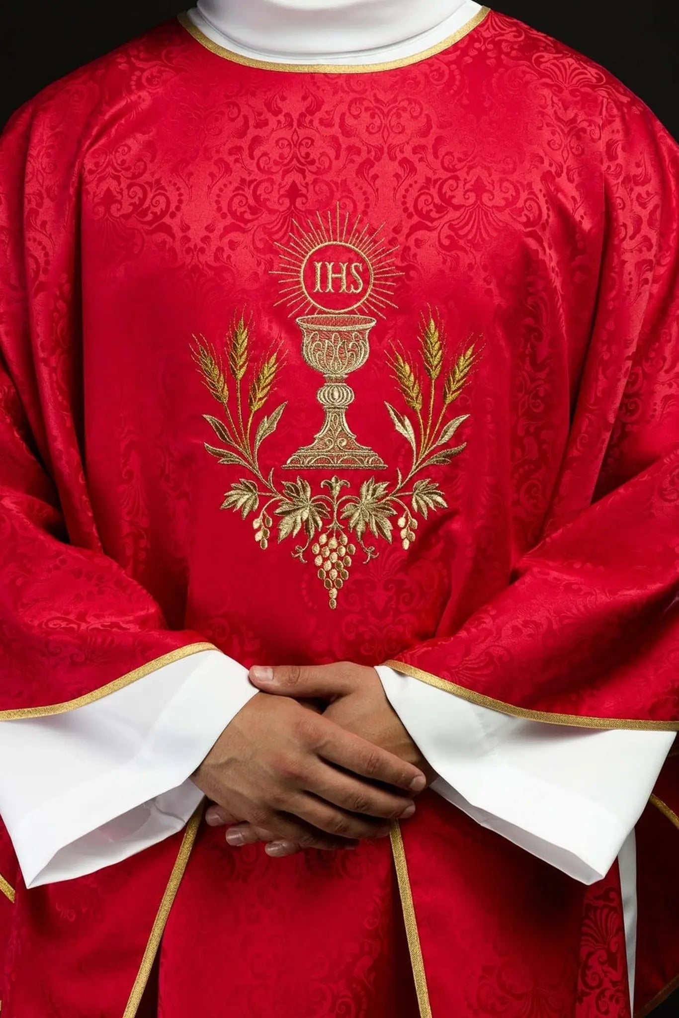 Casulla litúrgica roja con un cáliz bordado y una hostia sobre tela jacquard