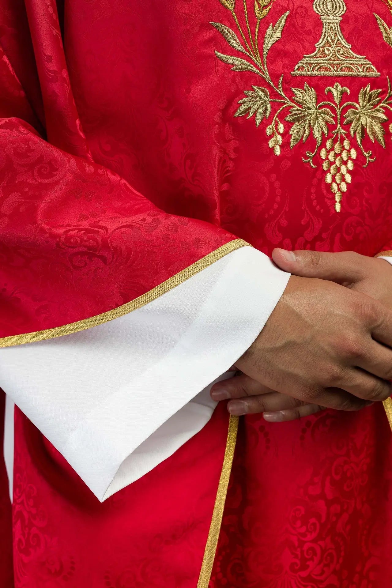 Red liturgical chasuble with an embroidered chalice and host on jacquard fabric