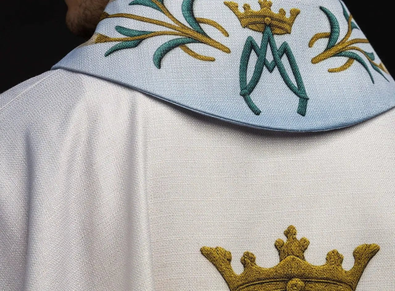 Casulla impresa mariana con patrón de lirios y monograma azul–crudo