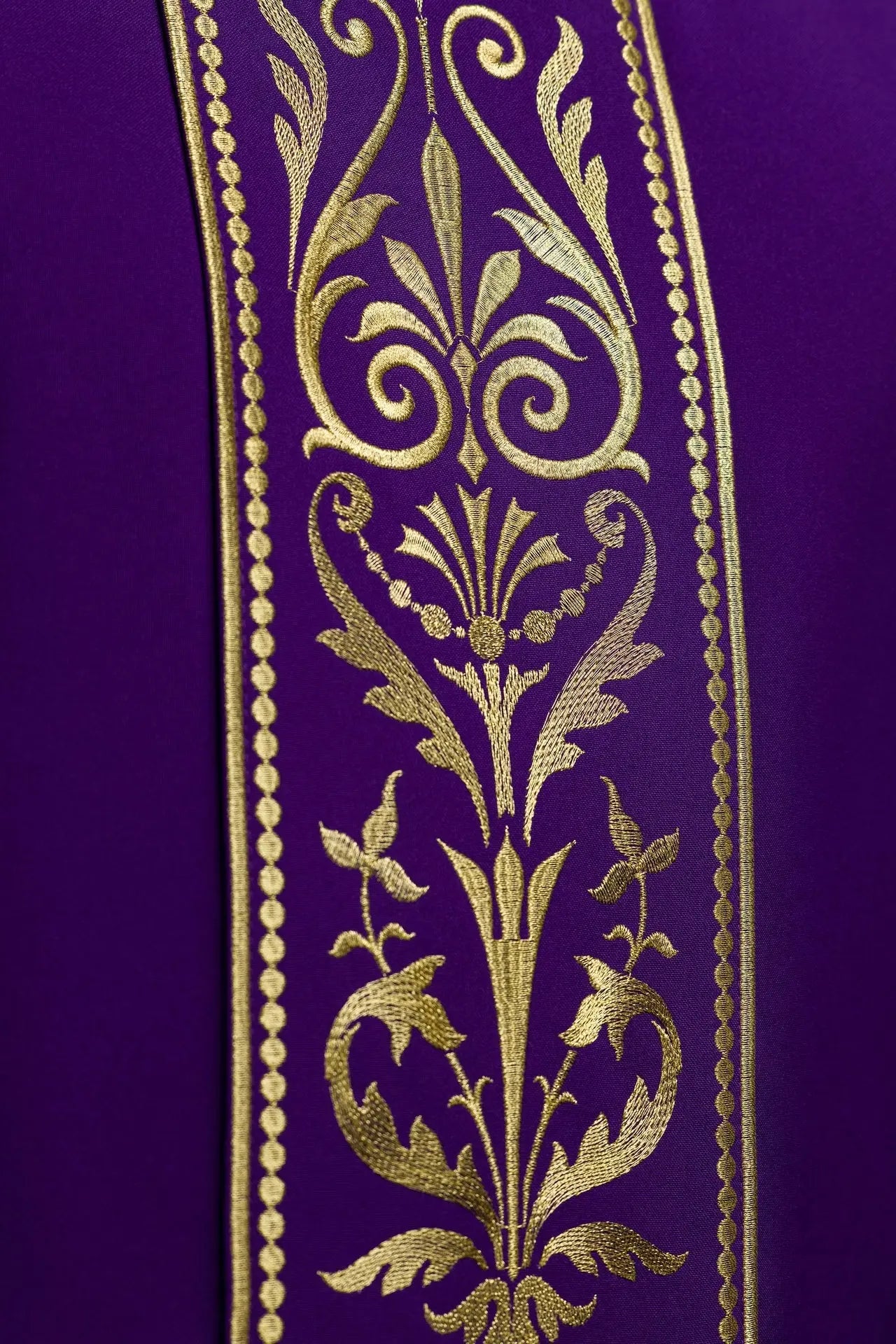 Casulla litúrgica púrpura decorada con cinturón bordado en oro