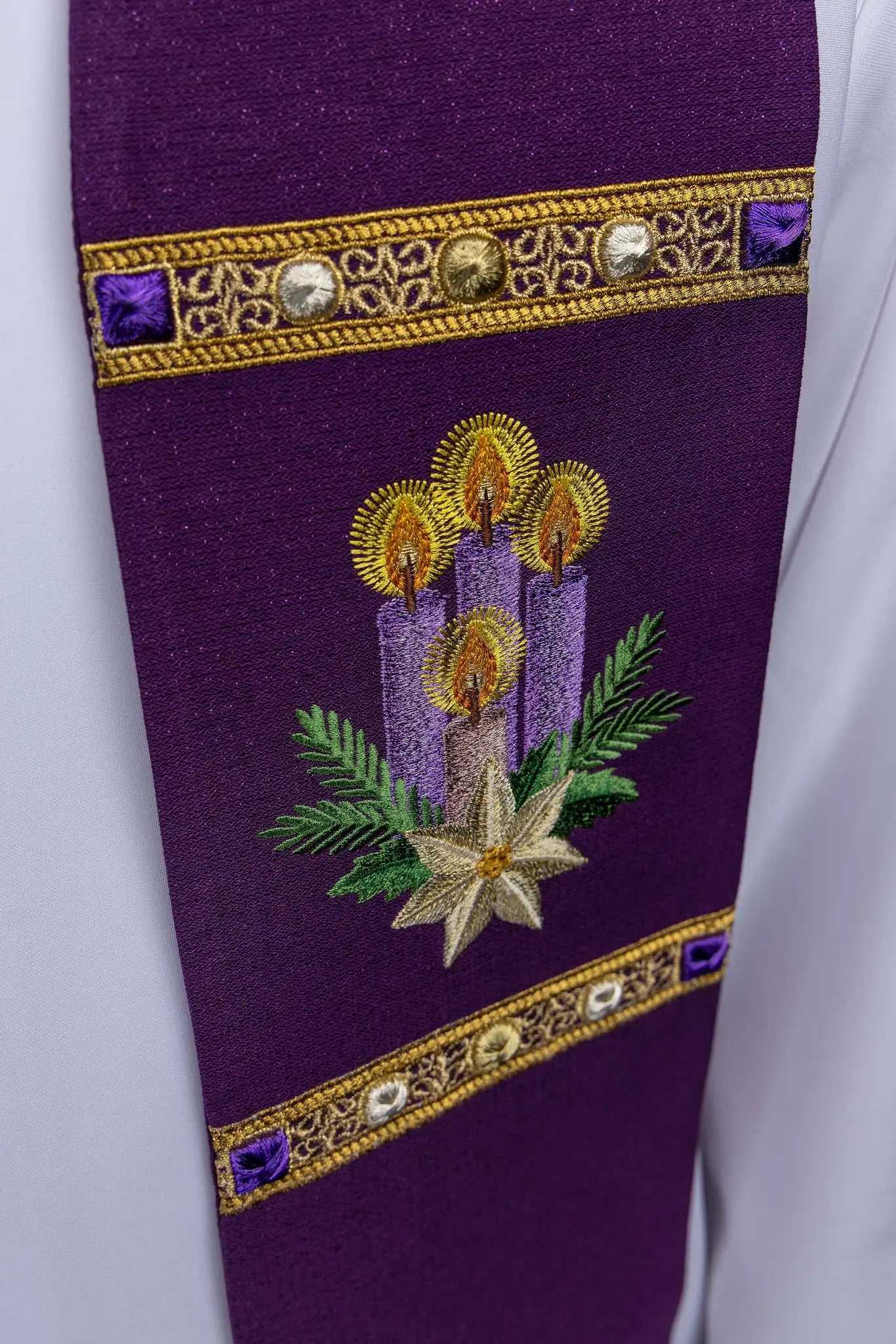 Purple Advent stole with gold IHS embroidery and Advent candle motif, made from shimmering fabric.