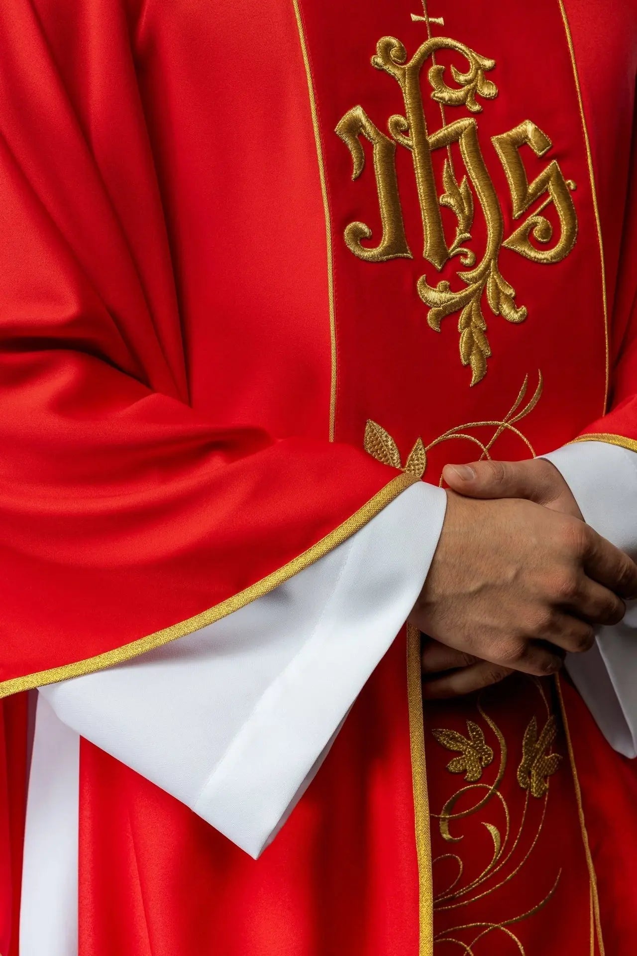 Casulla litúrgica roja con cinturón ricamente decorado con motivo floral e IHS
