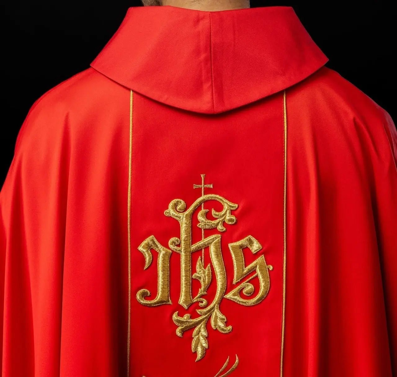 Casulla litúrgica roja con cinturón ricamente decorado con motivo floral e IHS