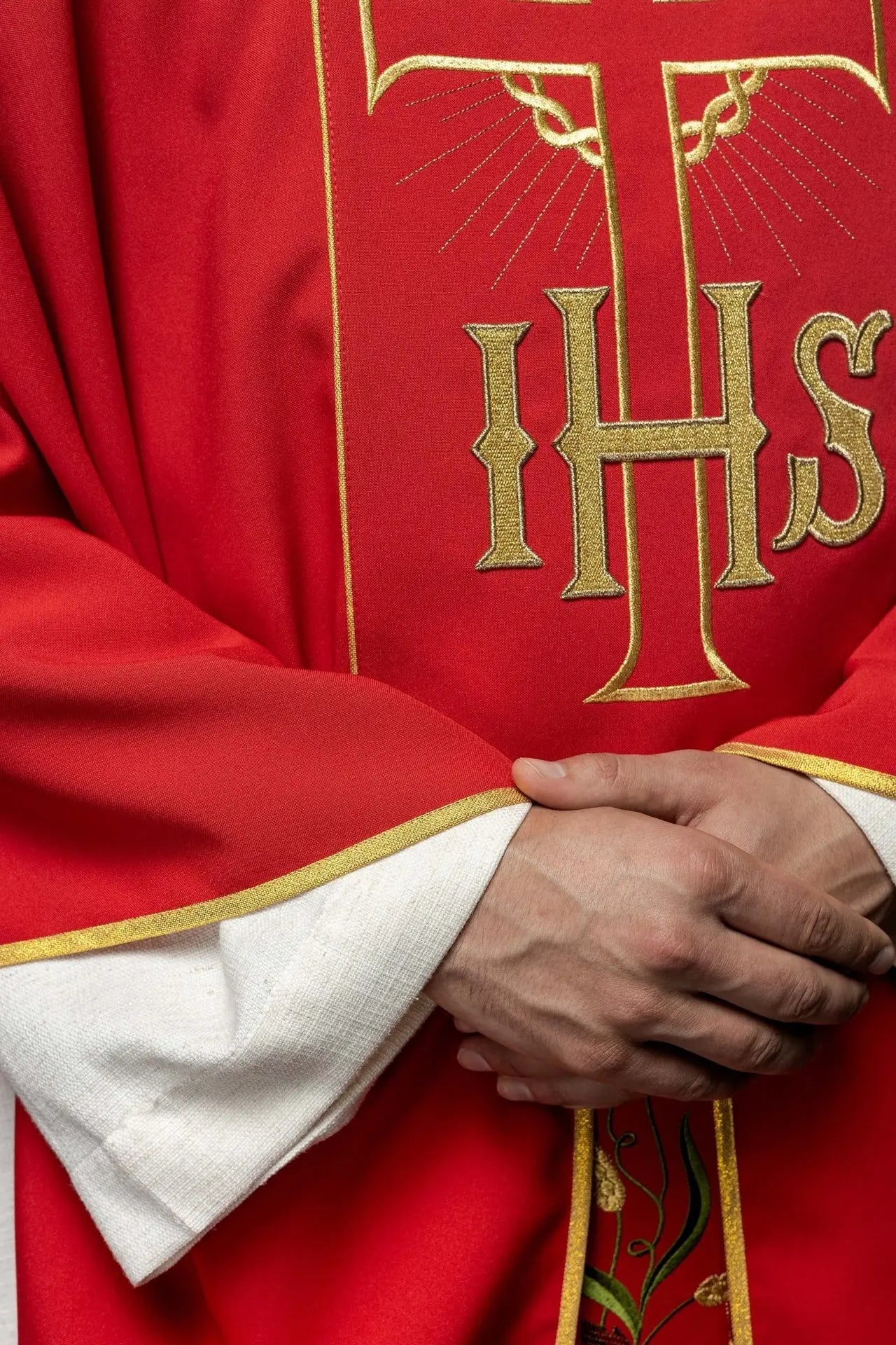 Casulla roja con cinturón dorado decorado con IHS y espigas