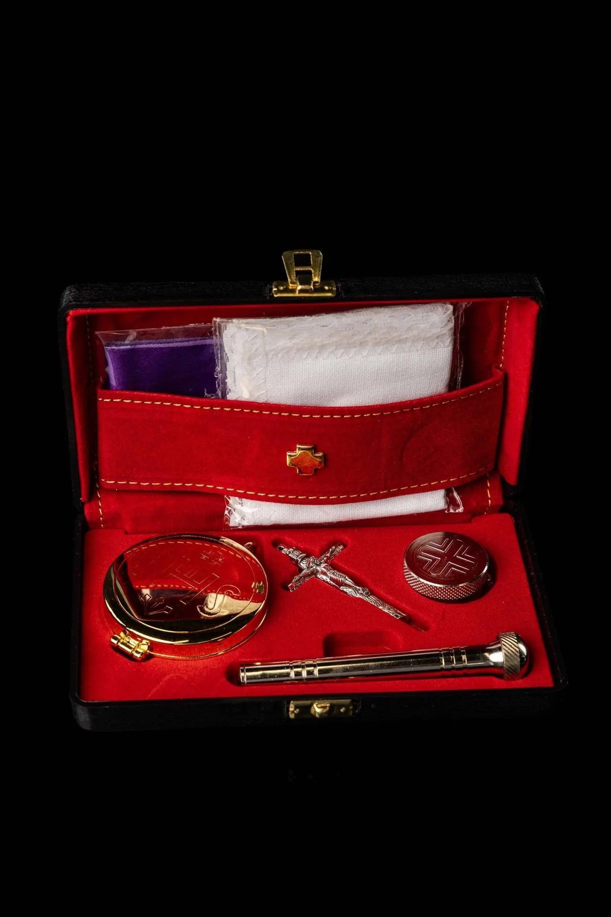 Bursa litúrgica roja abierta con cruz dorada y accesorios, vista frontal