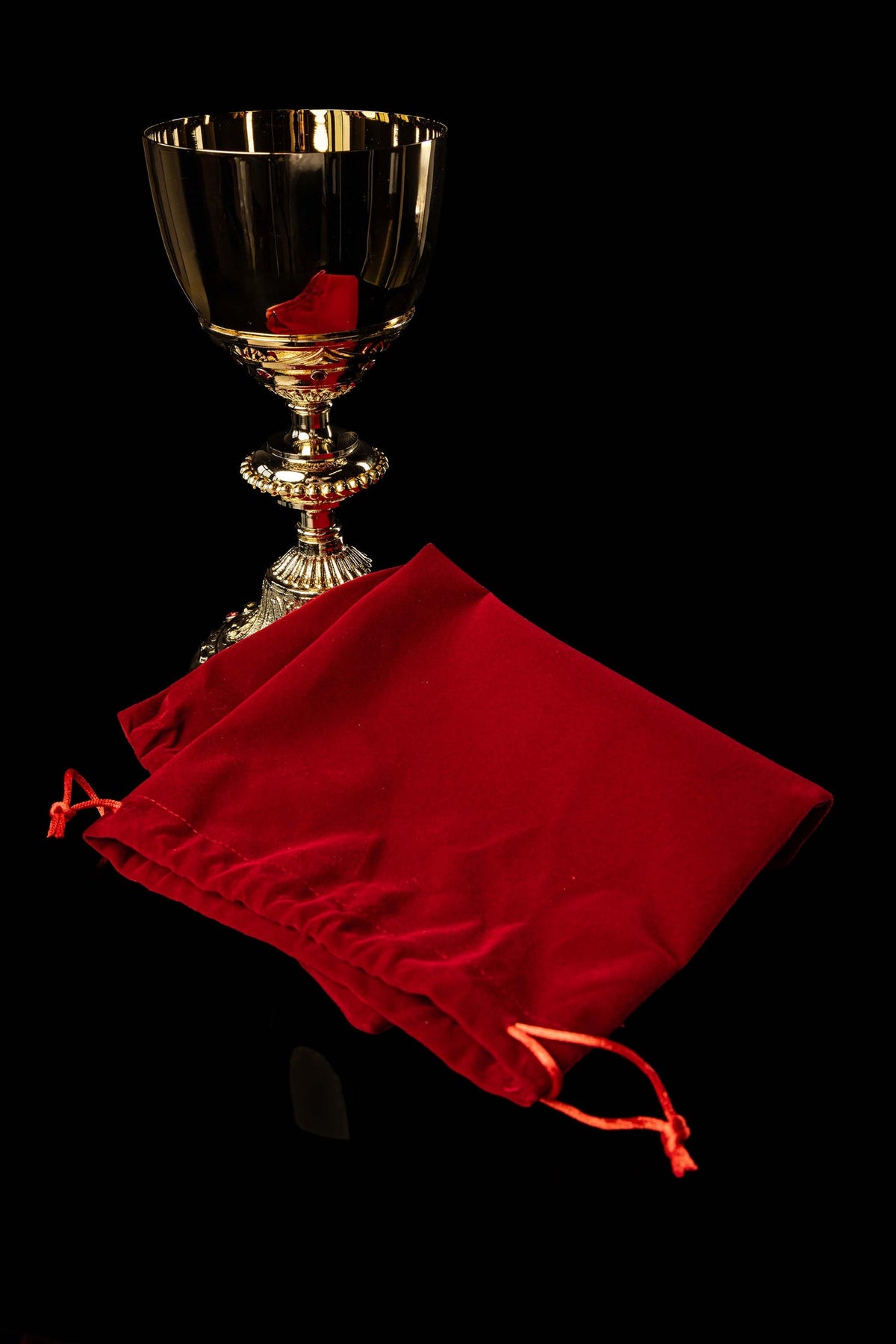 Gold-plated chalice with faux rubies and red protective pouch, full view
