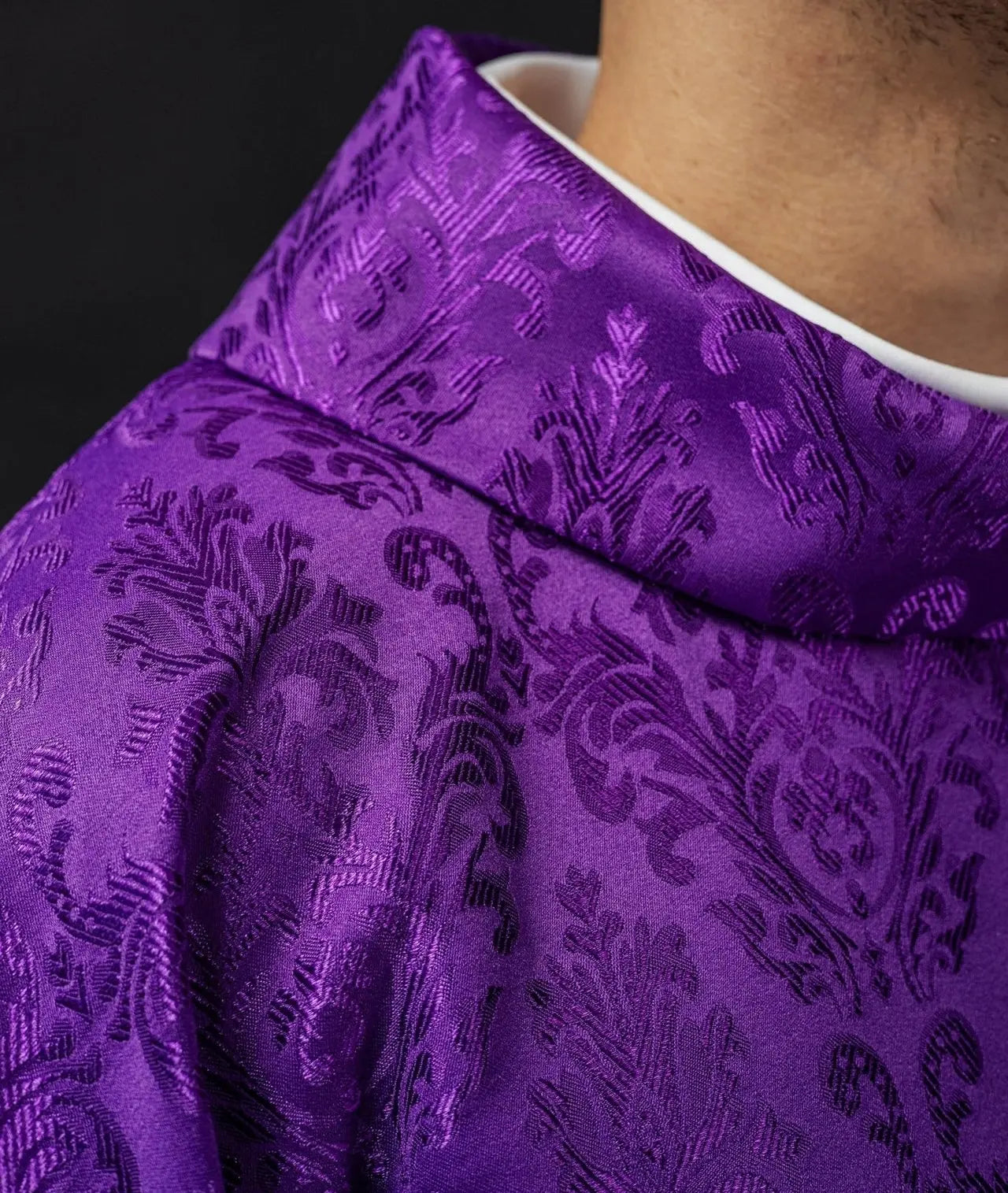 Purple chasuble with embroidered IHS motif on decorative fabric