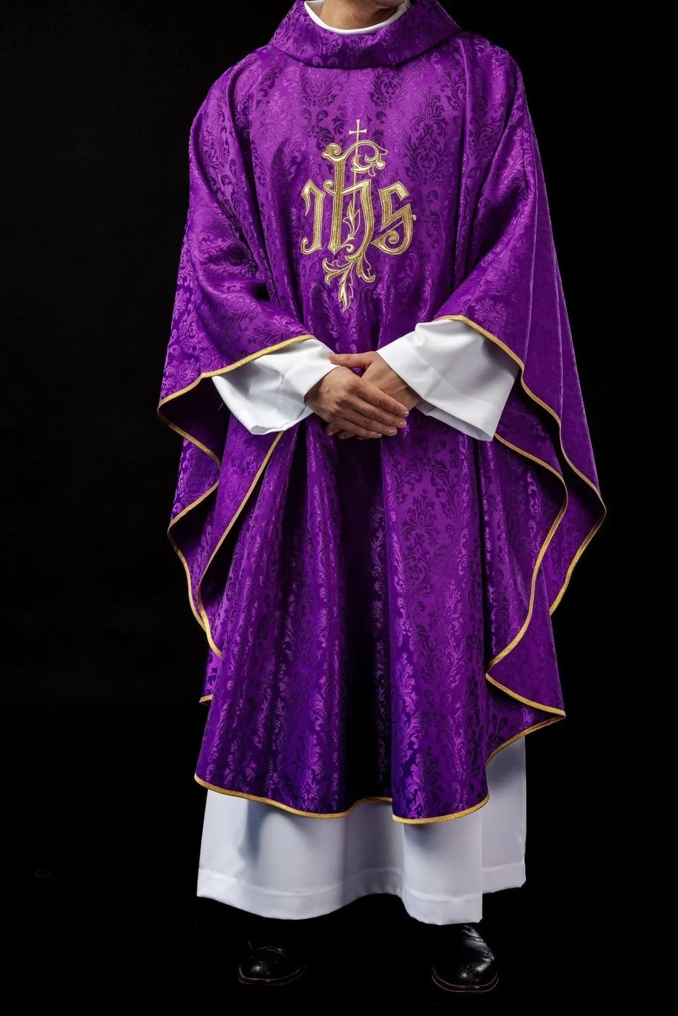 Purple chasuble with embroidered IHS motif on decorative fabric
