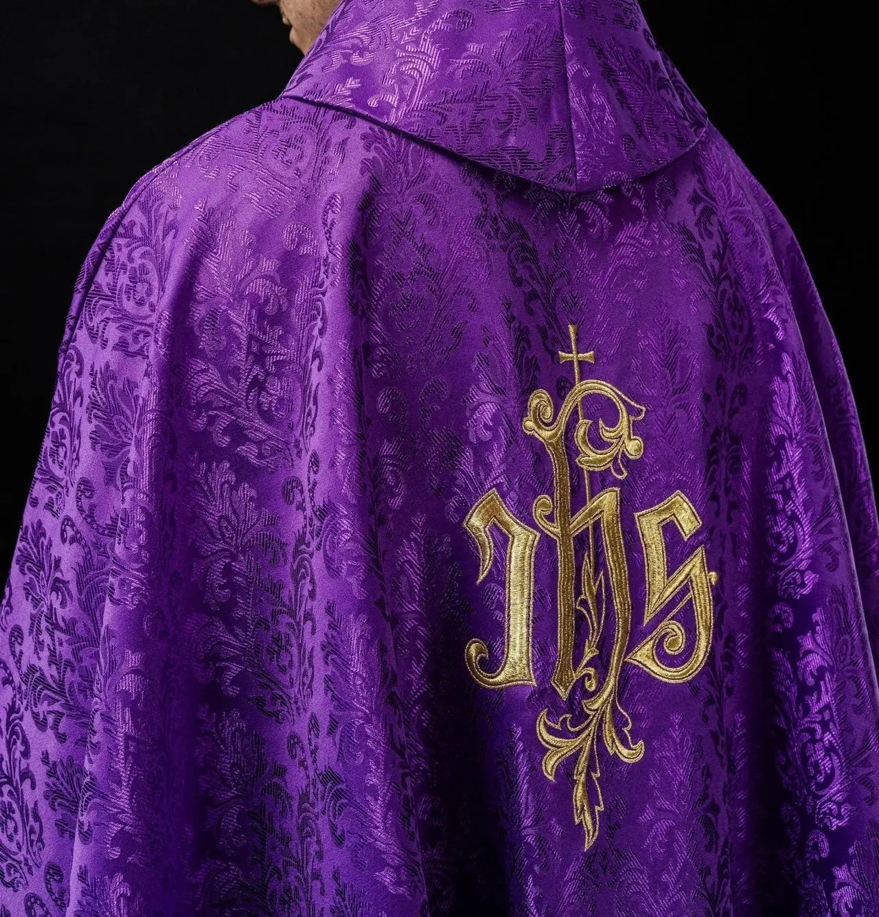 Purple chasuble with embroidered IHS motif on decorative fabric
