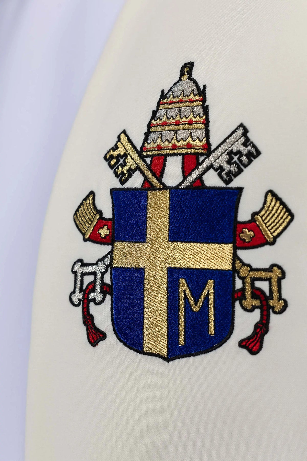 Marfil estola con galón central bordado, detalle del escudo pontificio
