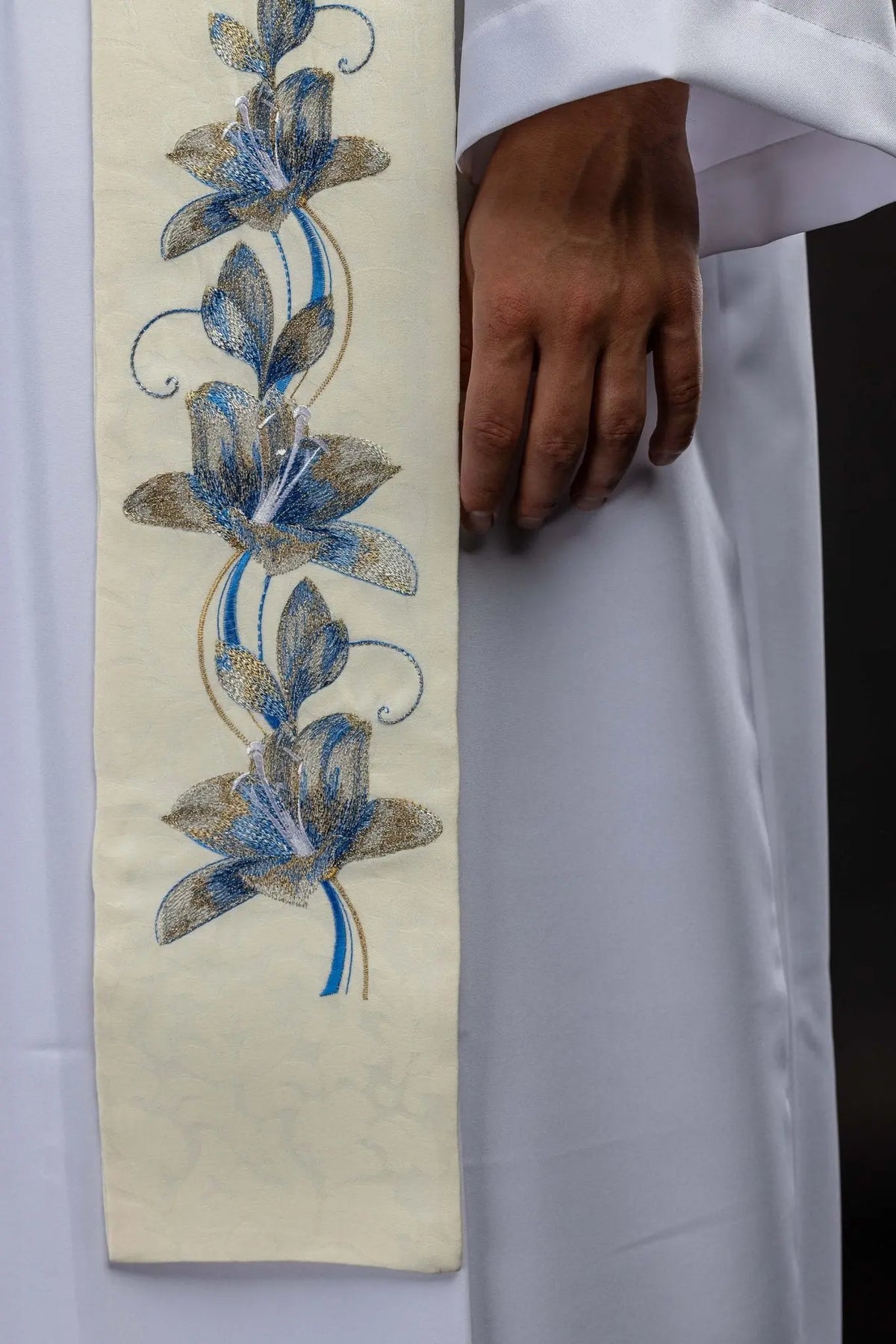 Marfil estola bordada con flores azules y doradas, detalle del extremo