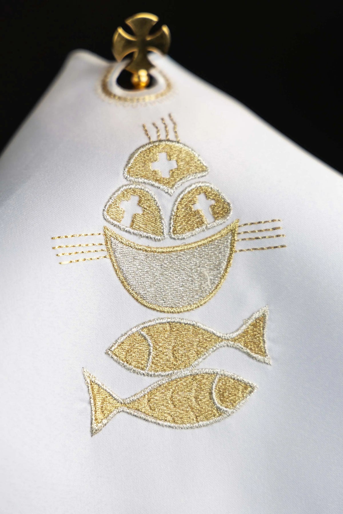 Blanco cubrecopón con bordado de pan y peces, vista cercana