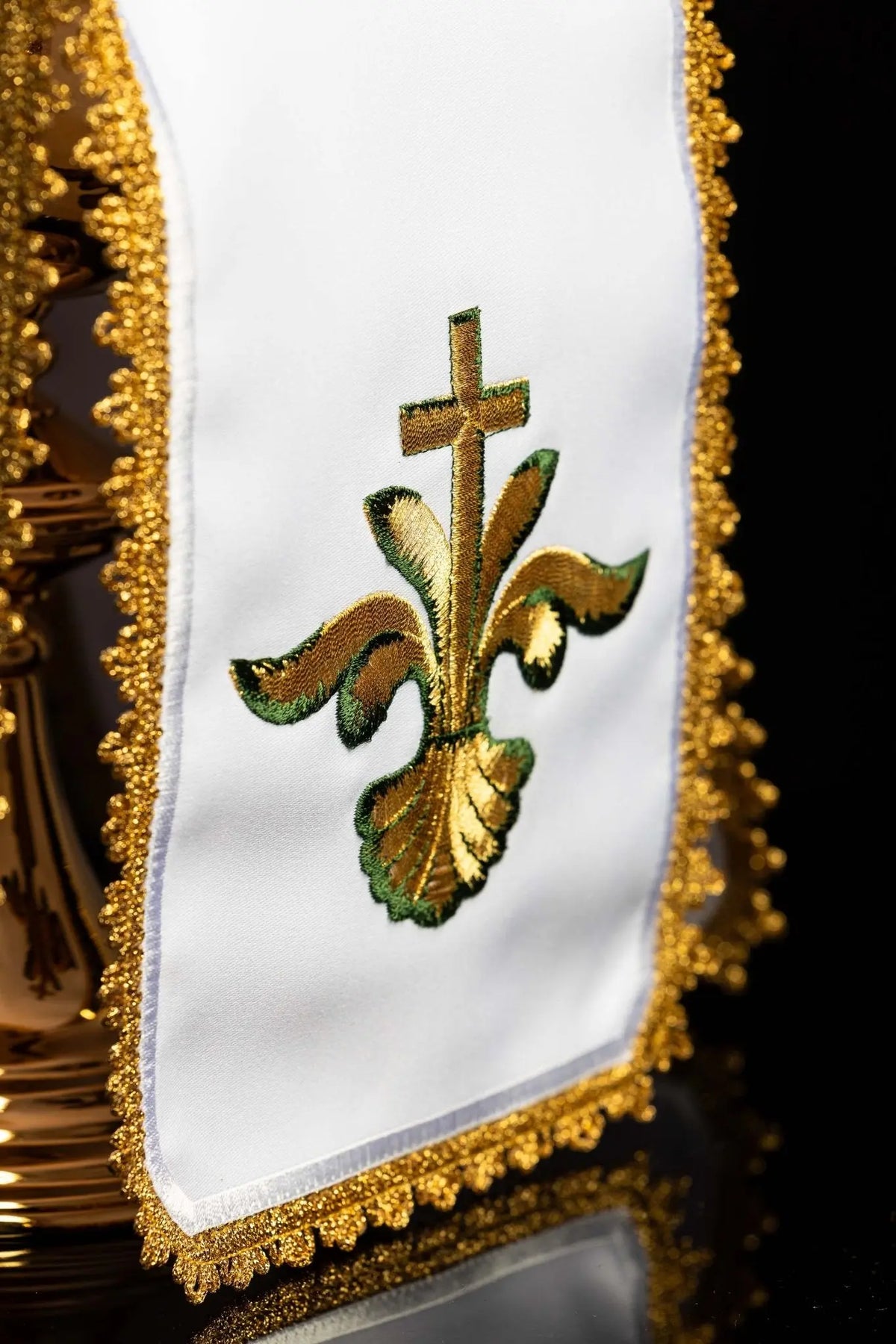 Blanco cubrecopón con bordado de cruz, detalle del bordado, vista cercana