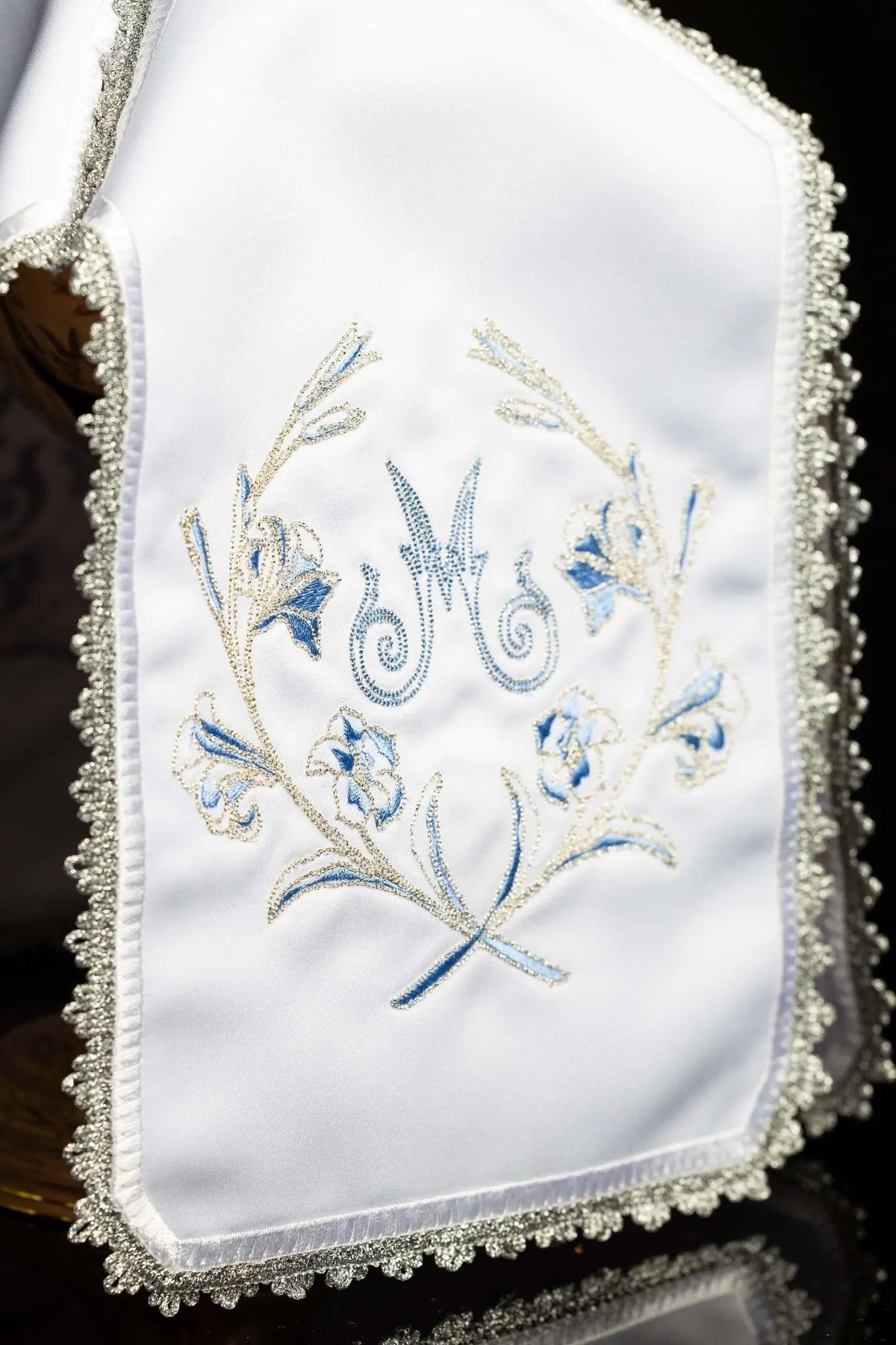 Blanco cubrecopón con bordado mariano plateado, detalle frontal