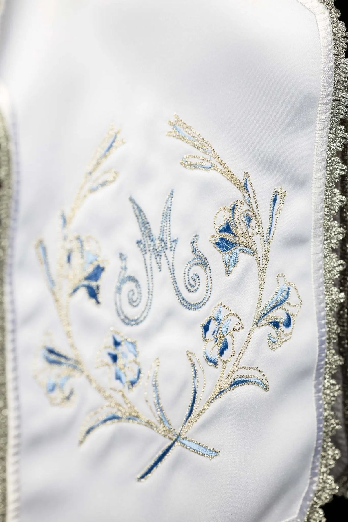 Blanco cubrecopón con bordado mariano plateado, detalle lateral