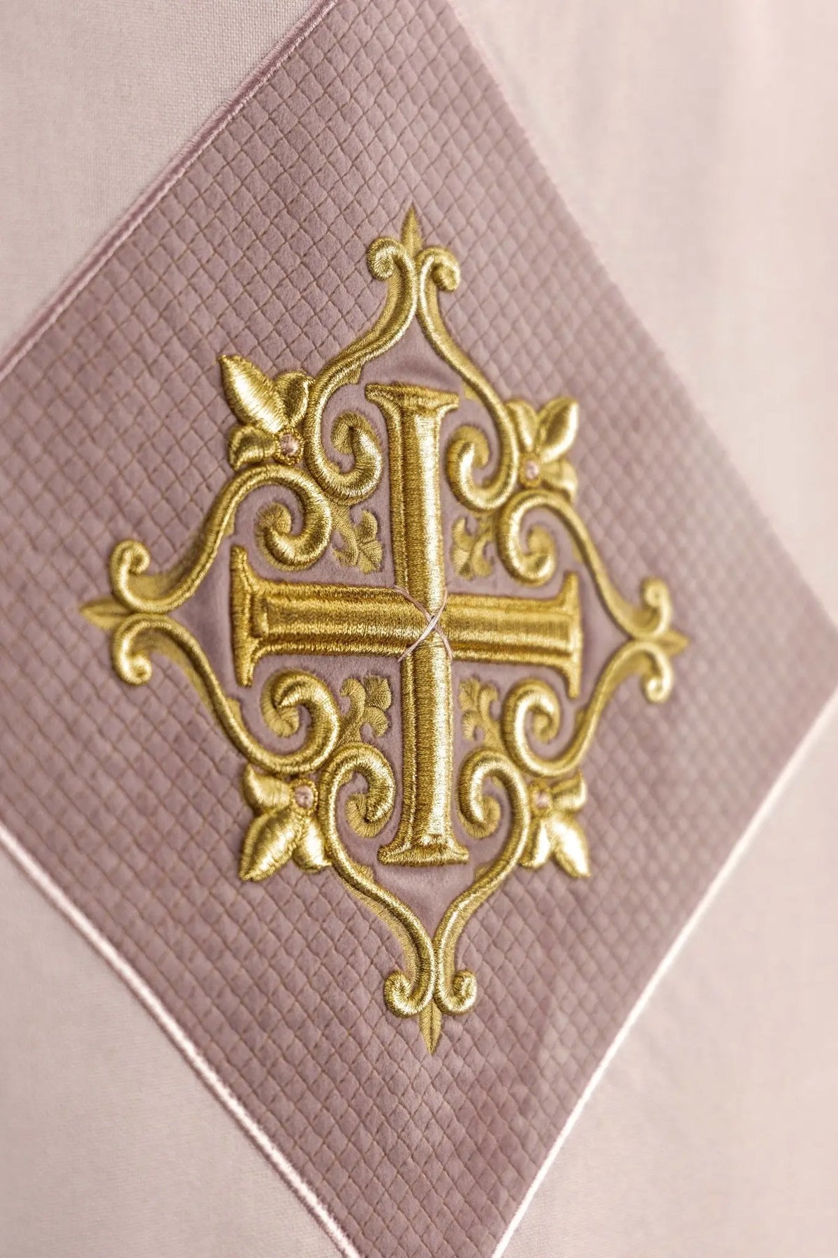 Paño de atril rosa con cruz dorada bordada, detalle del motivo