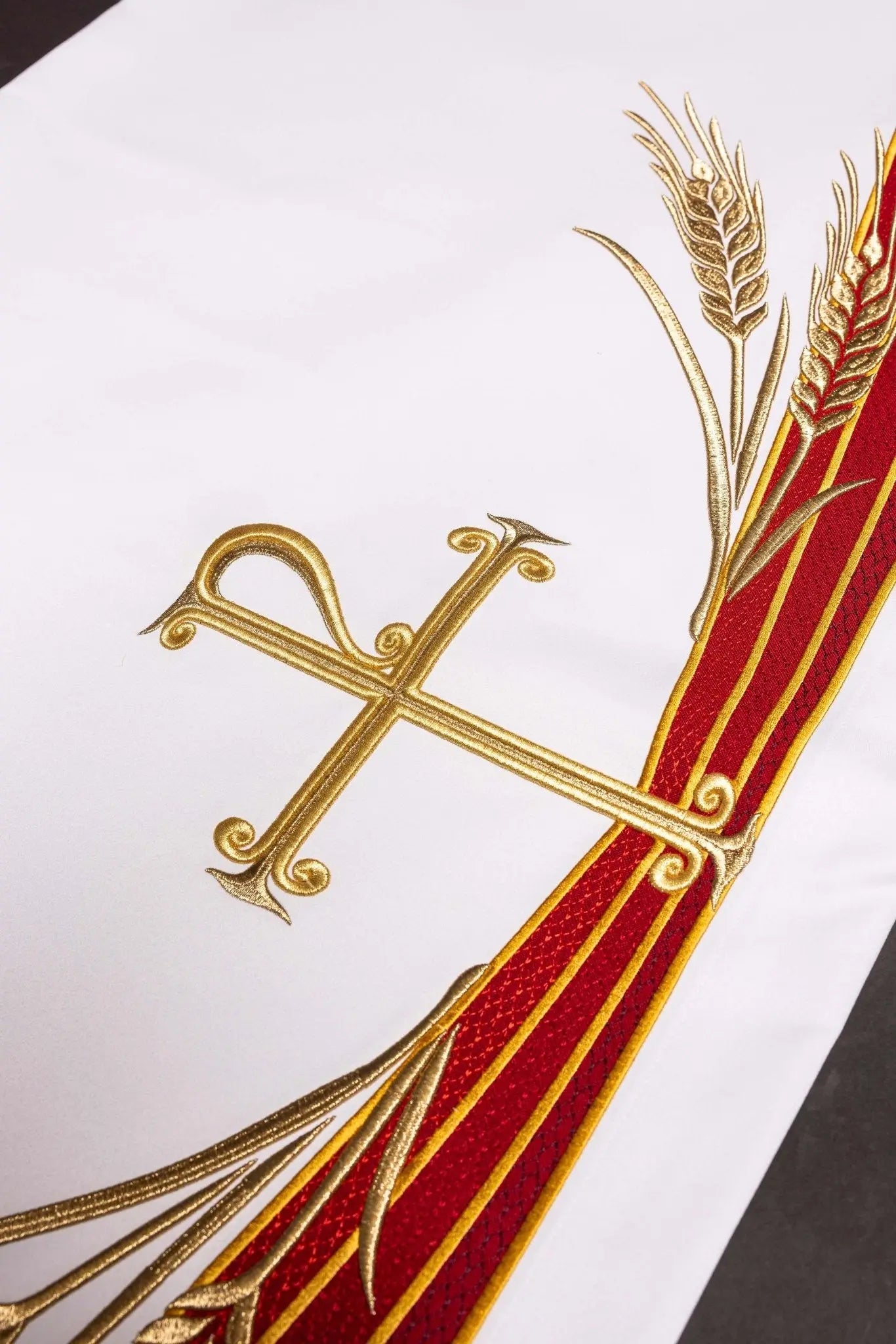 White altar cloth with embroidered Pax symbol, golden wheat sheaves, and red and gold trim
