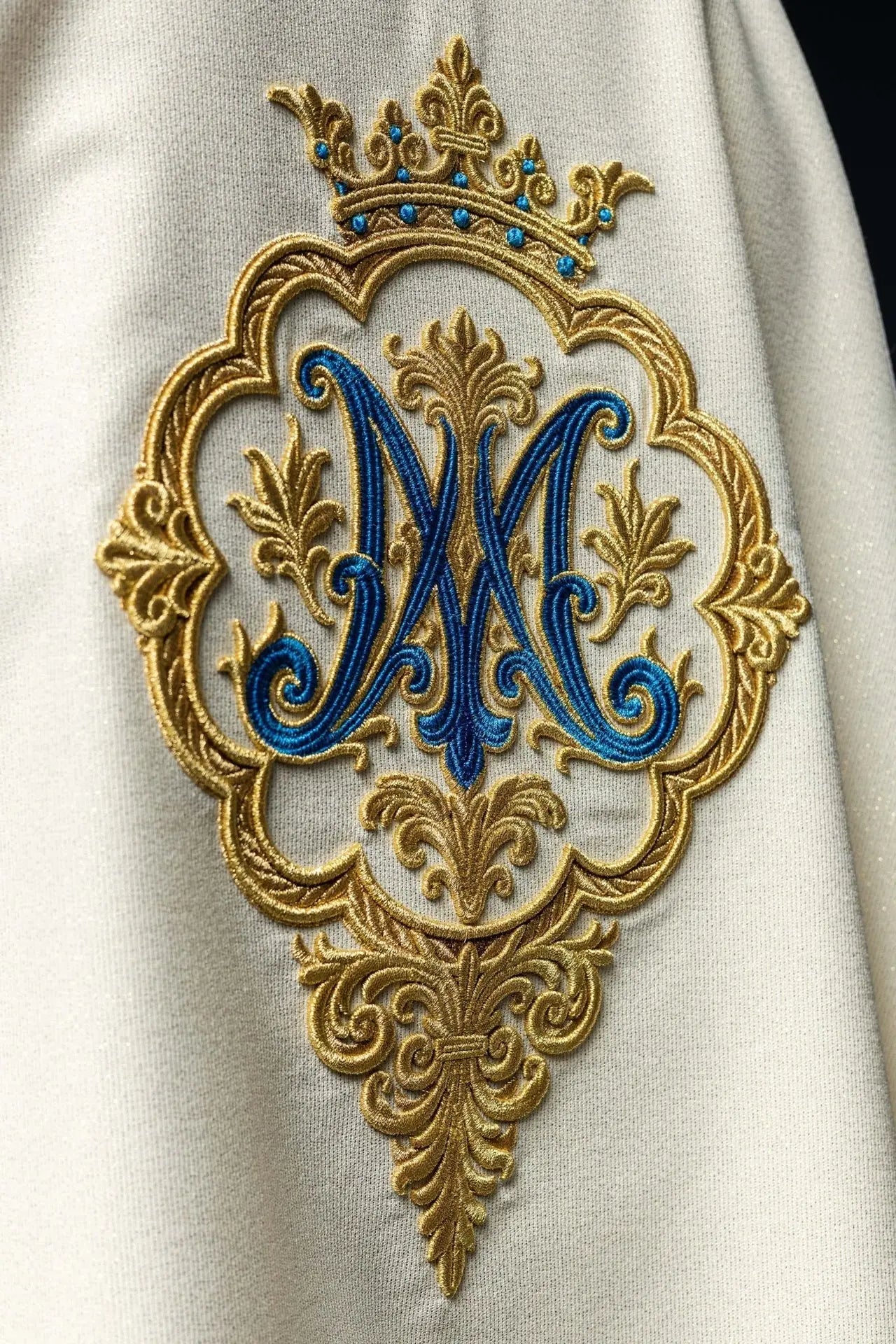 Casulla litúrgica con escudo mariano bordado y corona