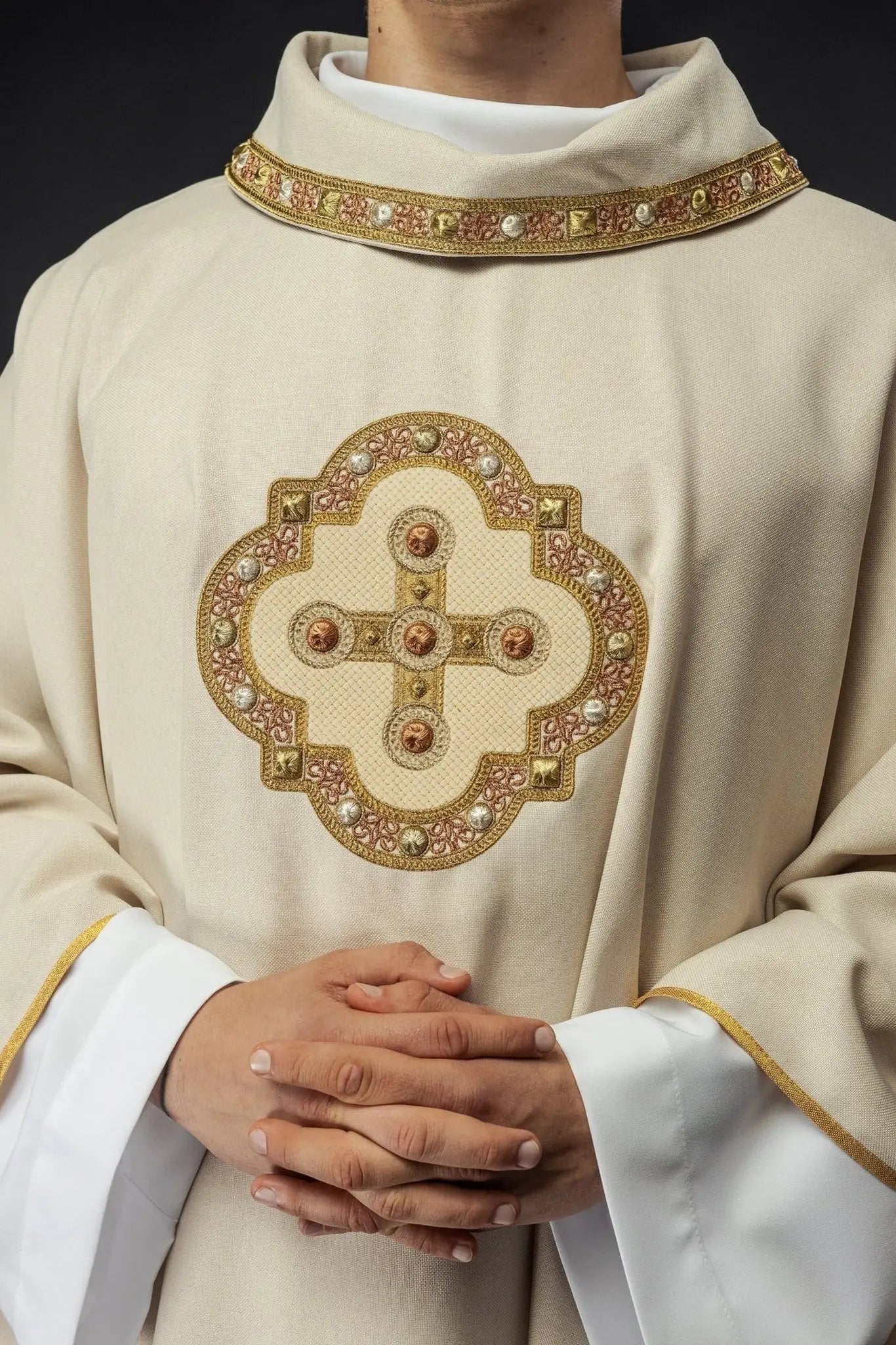 Chasuble in ecru color with embroidered trim on the collar and around the embroidery of the cross