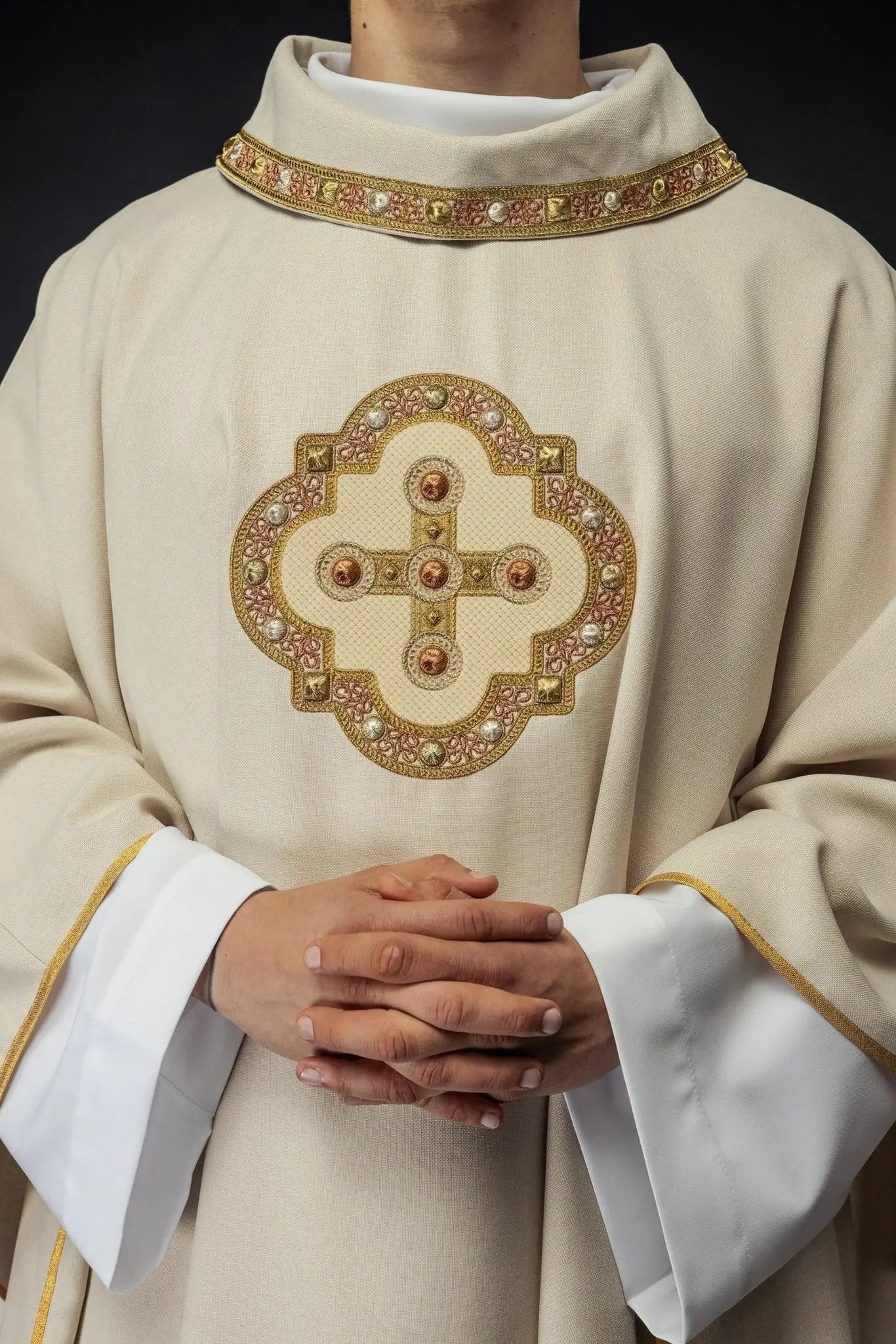 Chasuble in ecru color with embroidered trim on the collar and around the embroidery of the cross