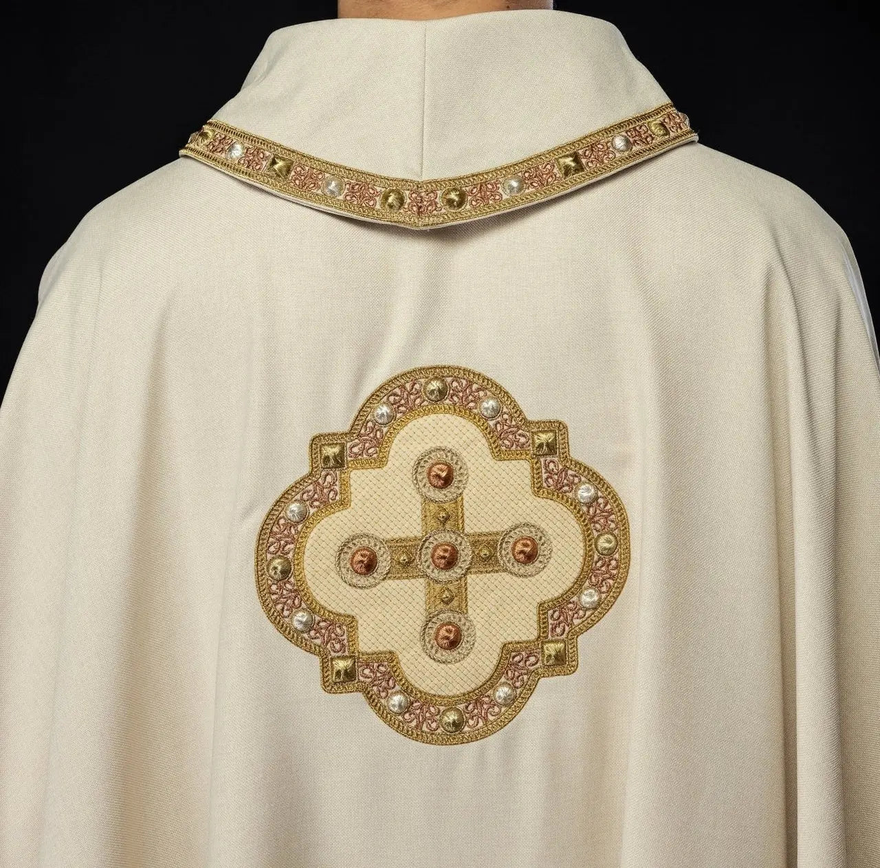 Chasuble in ecru color with embroidered trim on the collar and around the embroidery of the cross