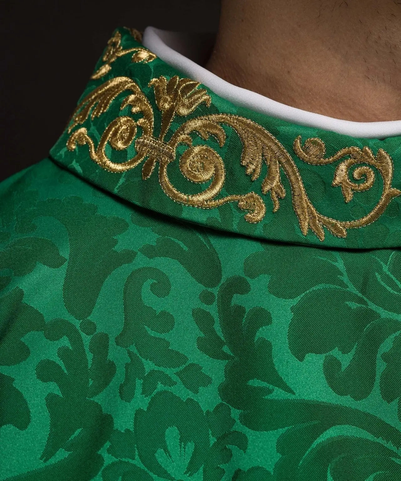 Green chasuble with IHS motif and richly embroidered collar on decorative fabric