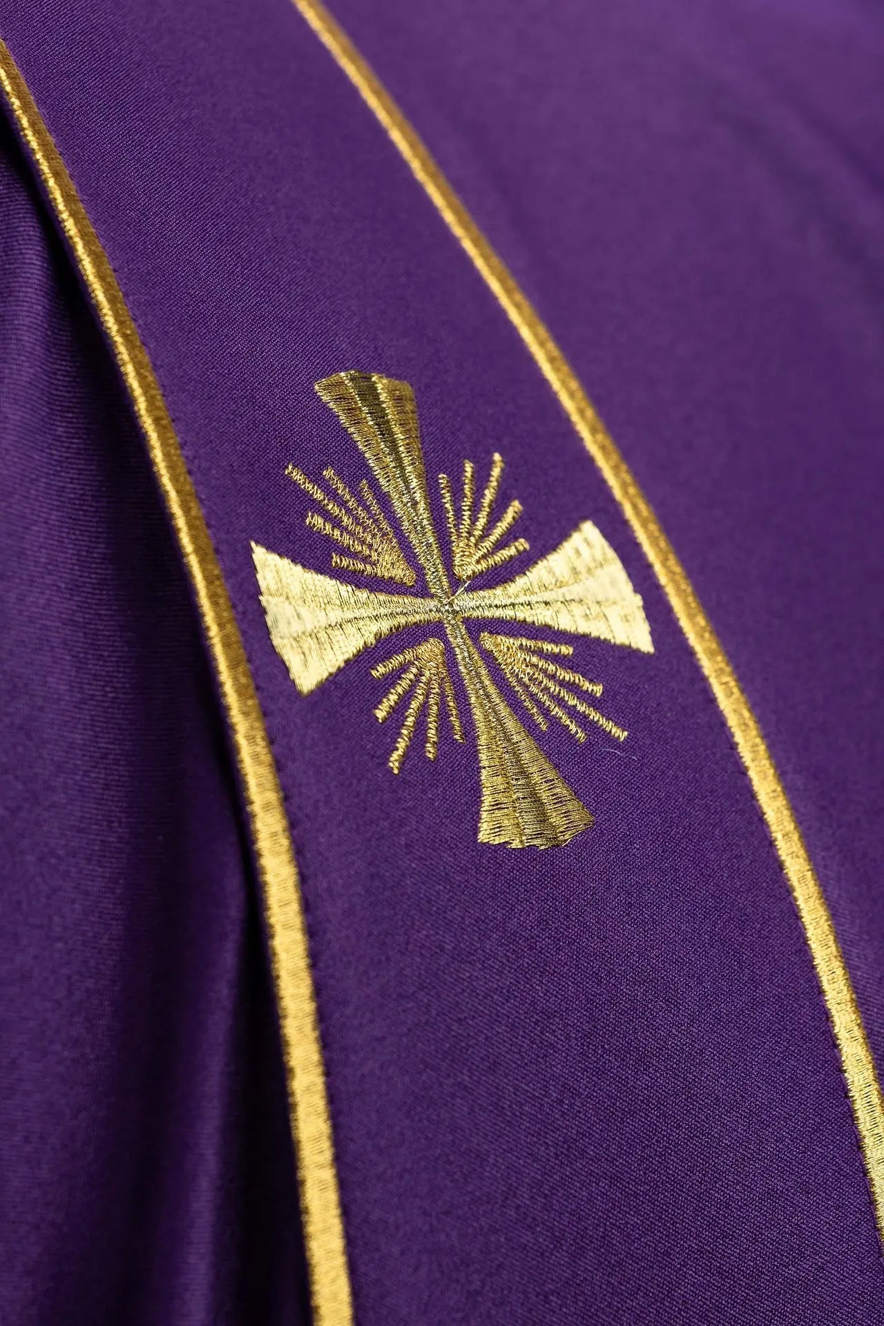 Dalmatica morada con bandas decorativas y bordado de cruz dorada