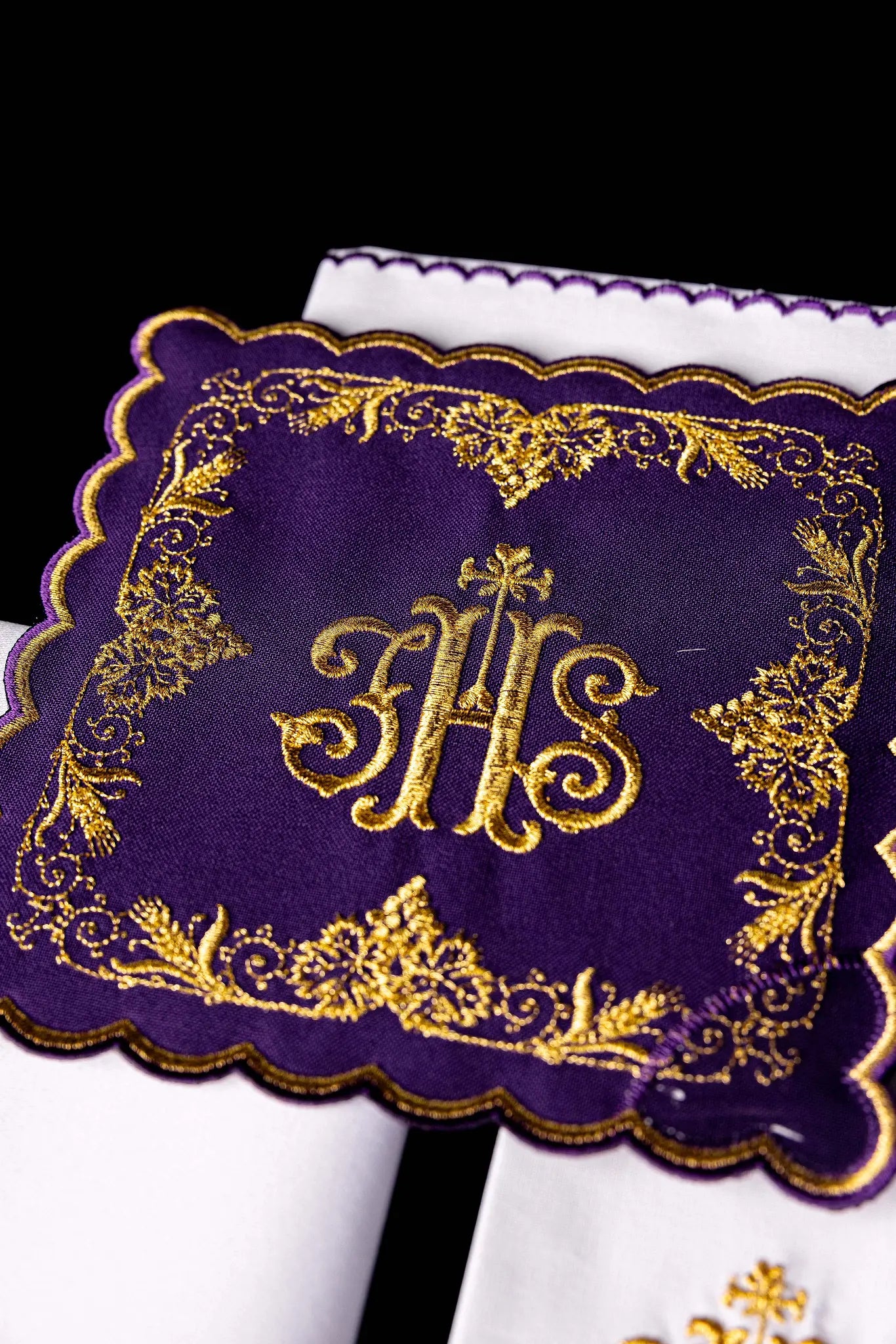 Purple chalice linen set with gold IHS embroidery, vine leaves, and wheat sheaves. Includes a purple pall, white corporal with IHS, and white purificator and lavabo towel with gold crosses and purple scalloped edges.