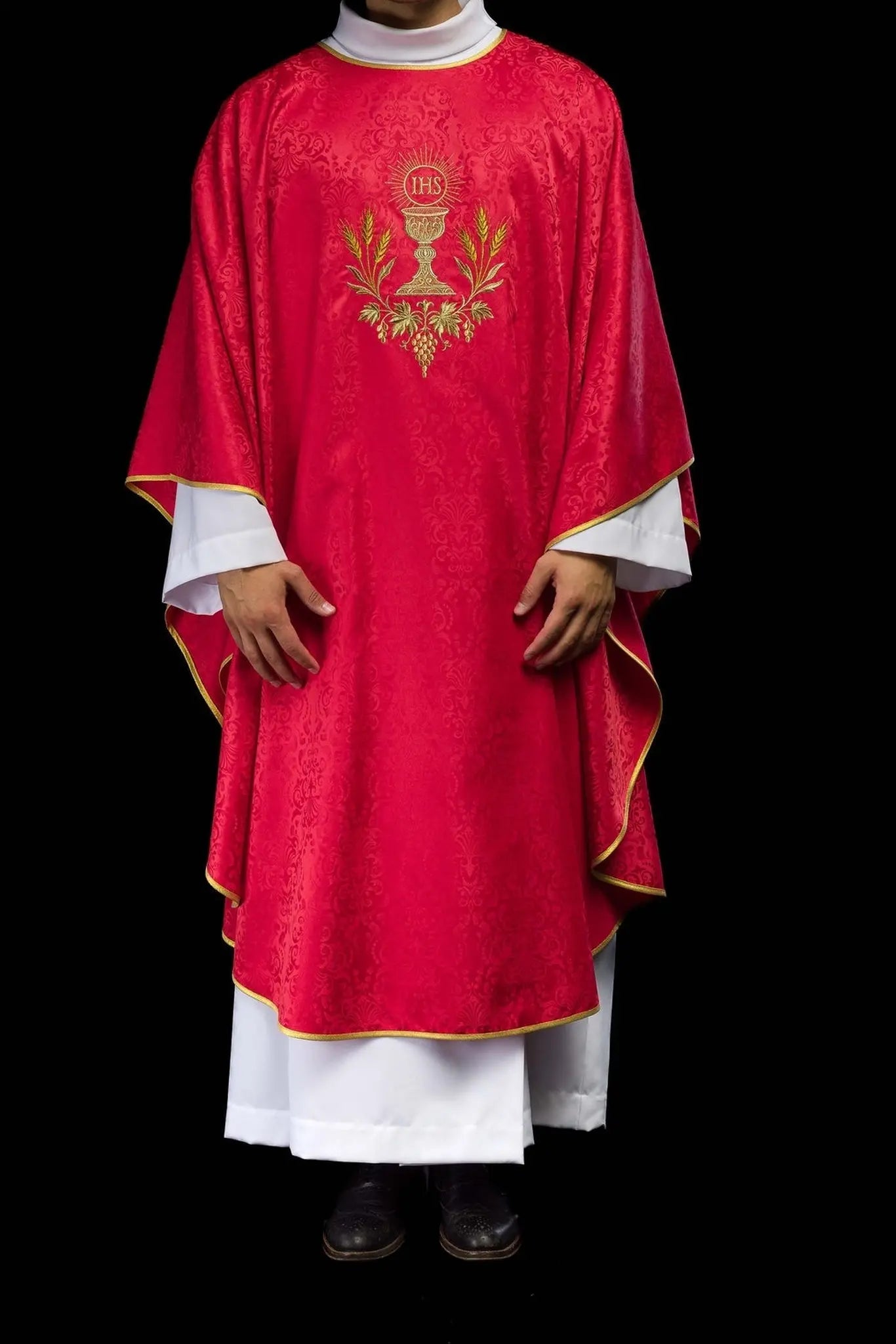 Casulla litúrgica roja con un cáliz bordado y una hostia sobre tela jacquard