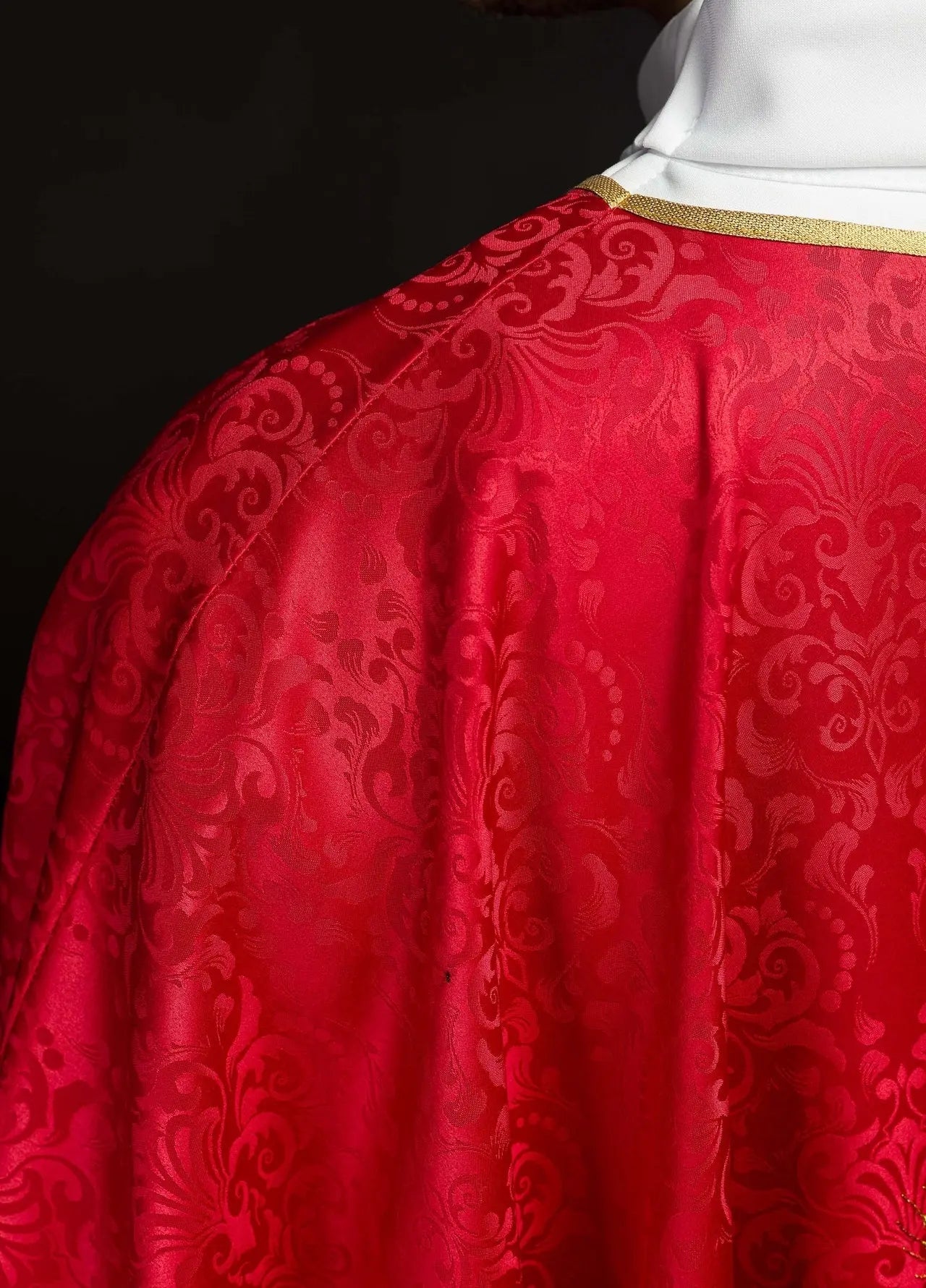 Casulla litúrgica roja con un cáliz bordado y una hostia sobre tela jacquard