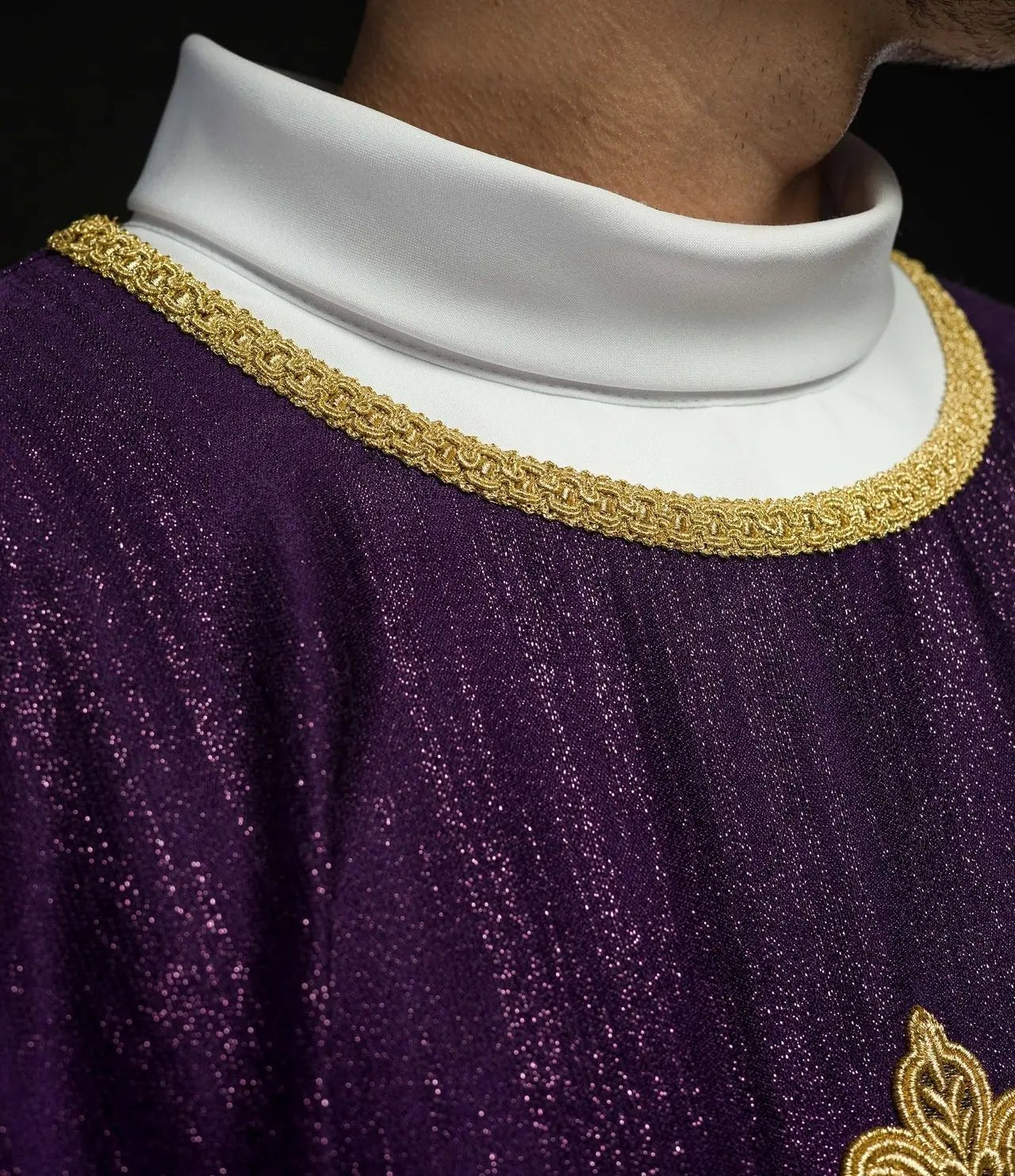 Casulla litúrgica púrpura con un motivo de cruz bordada en tela decorativa