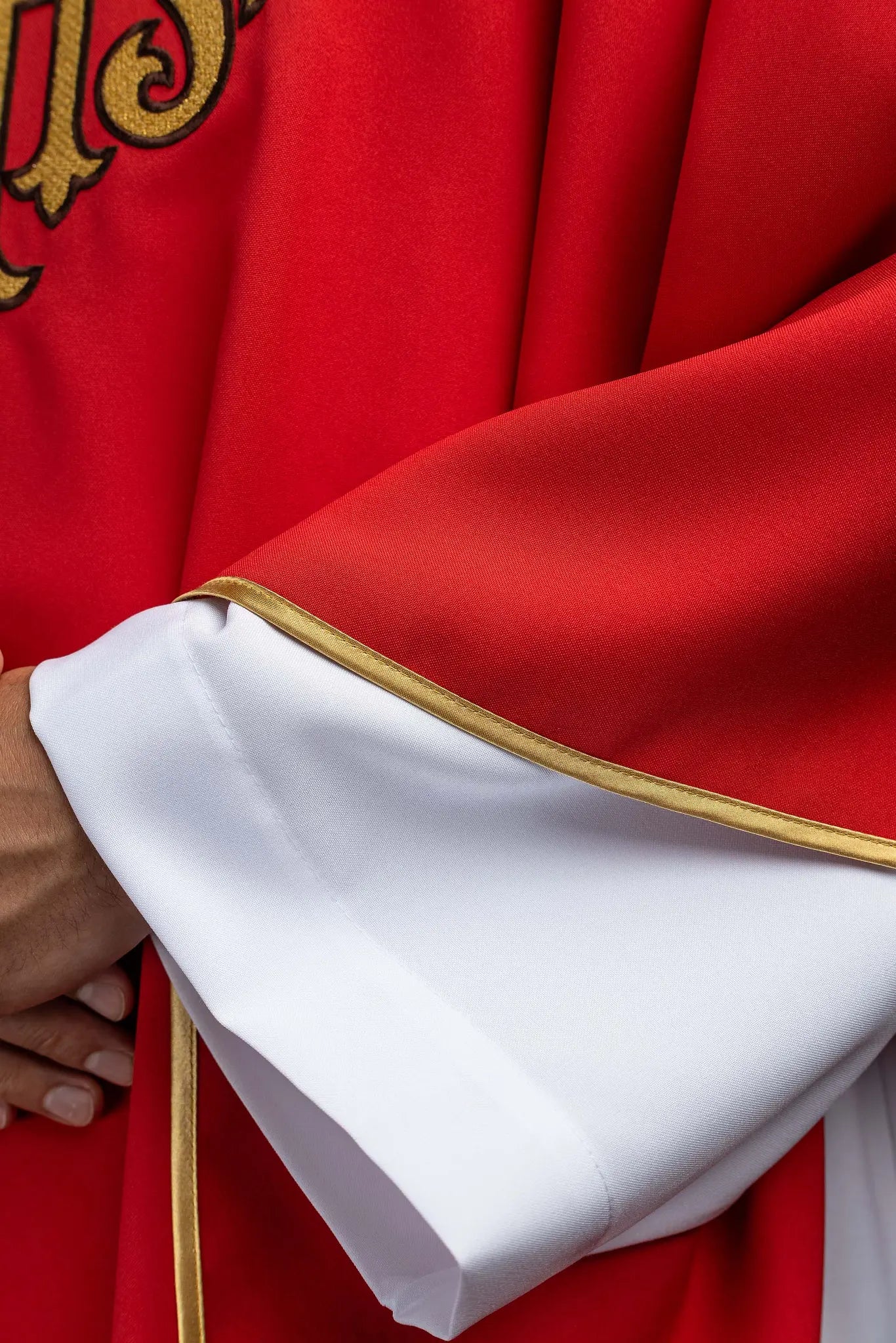 Red chasuble with gold IHS embroidery on the front and back, finished with gold trim and a V-neckline.