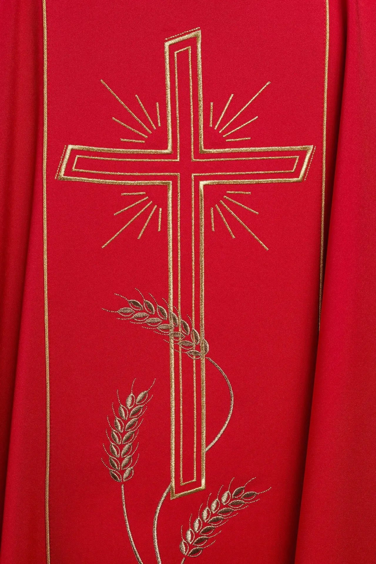 Casulla roja con amplia franja bordada dorada y cruz IHS
