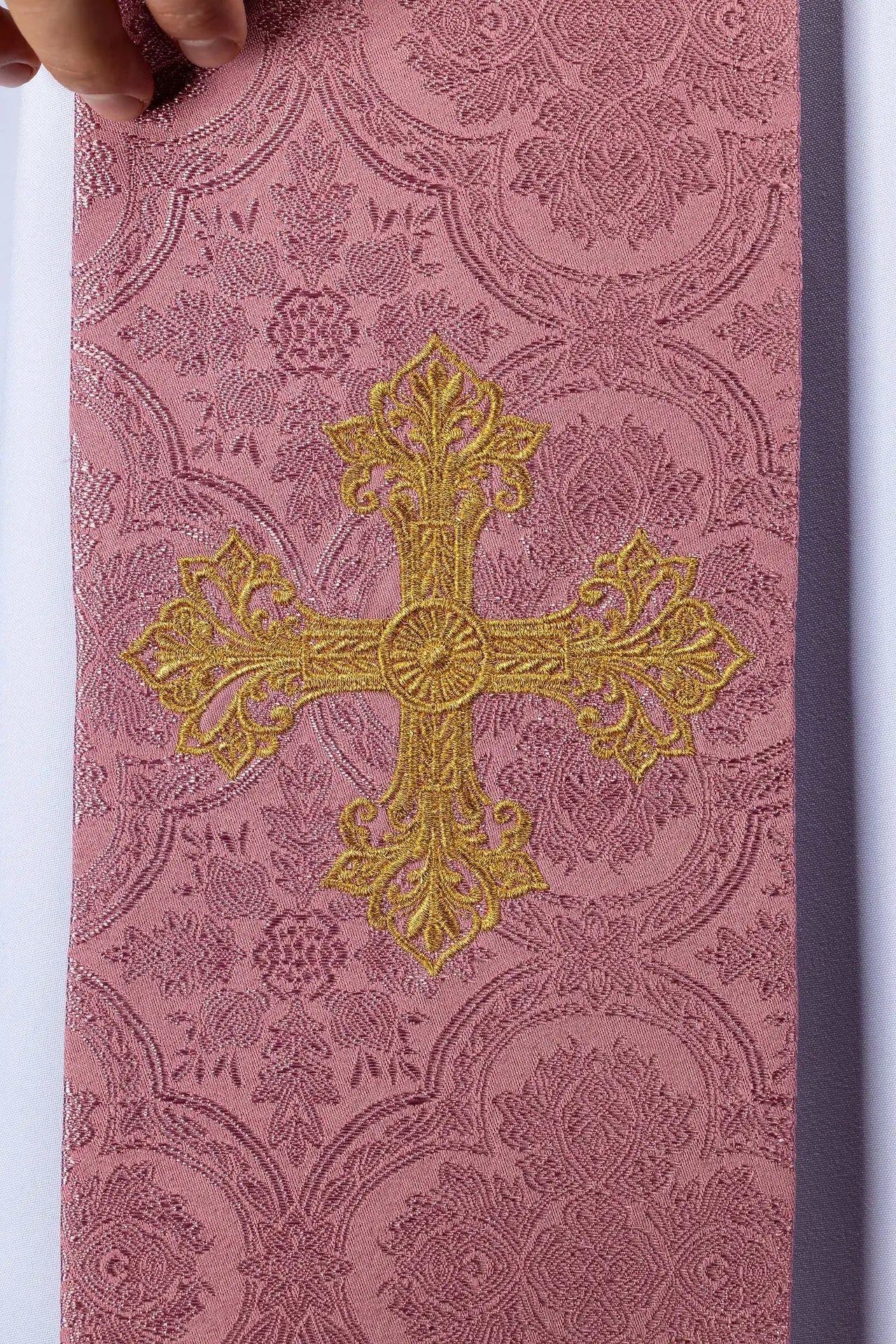 Estola rosa de jacquard con bordado de cruz dorada