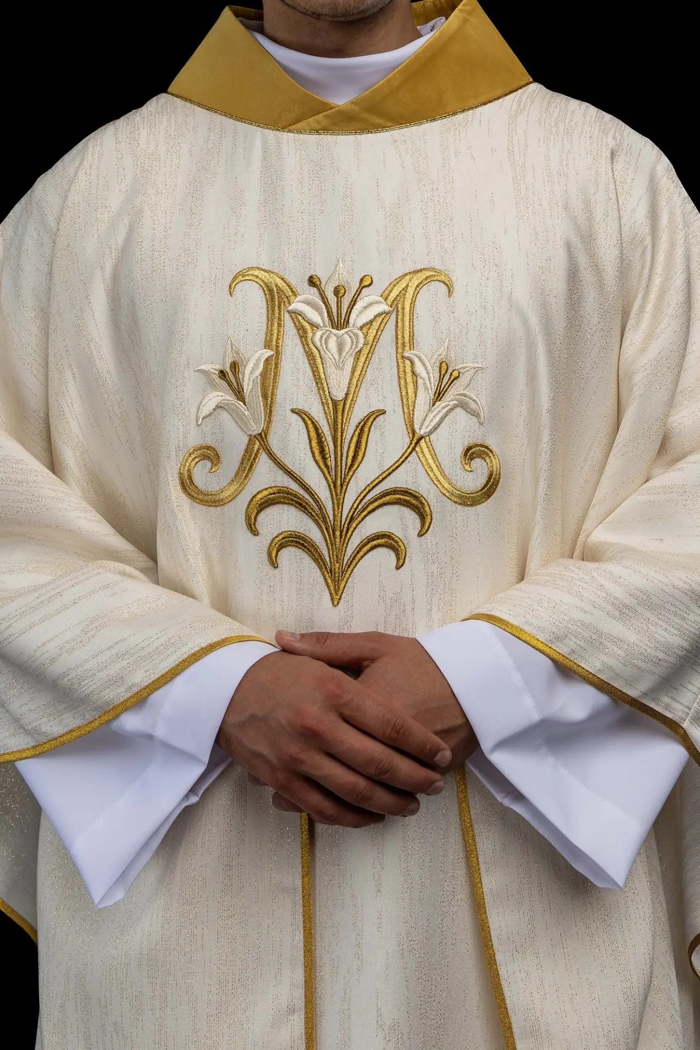 Ecru chasuble with Marian lily embroidery, gold collar, and gold trim.