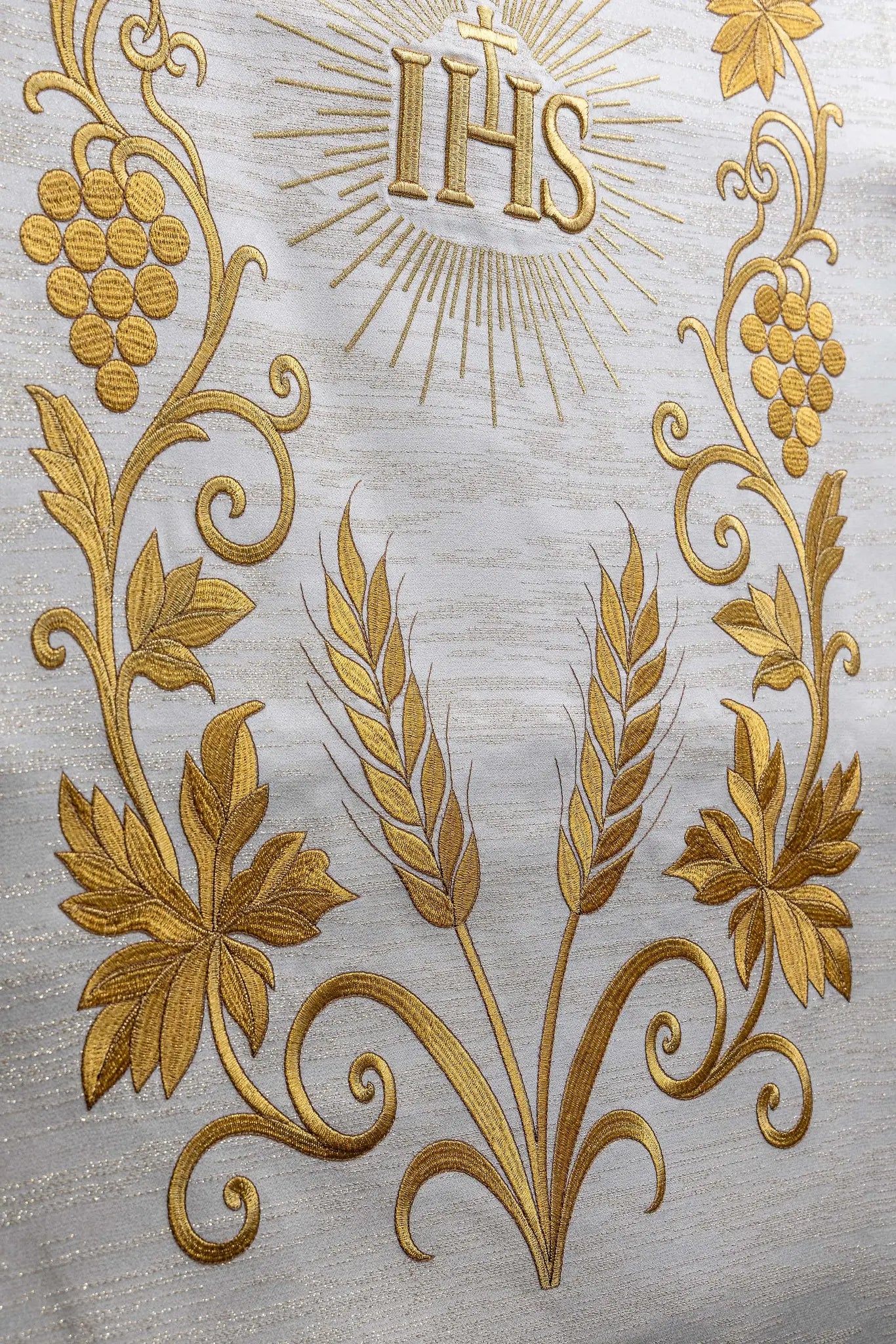 Ecru lectern cover with rich gold IHS monogram embroidery, radiant glory, wheat sheaves, and grapevines, finished with gold fringes.