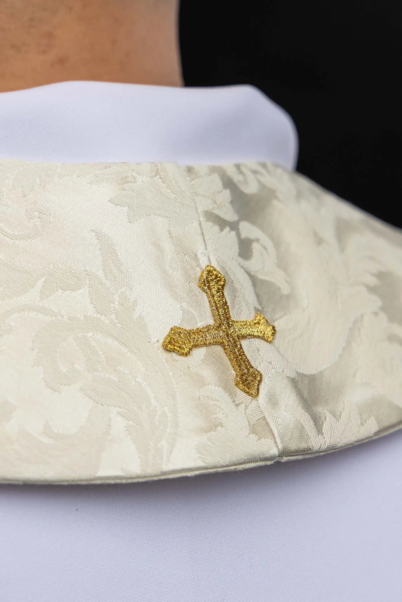 Ecru stole with Holy Family image on one side and IHS monogram on the other, featuring gold trim and tassels.