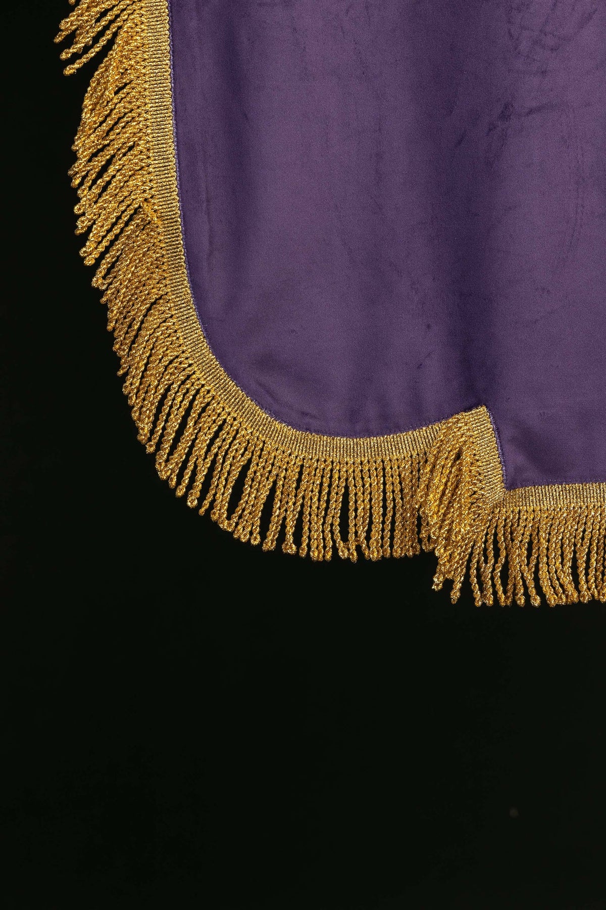 Morado estandarte con flecos dorados, primer plano del borde inferior