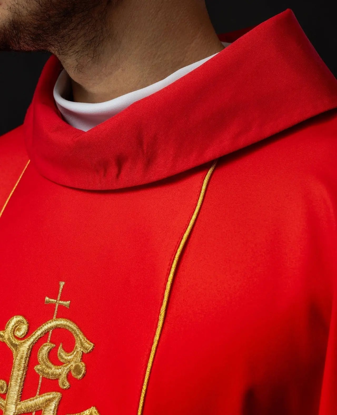 Casulla litúrgica roja con cinturón ricamente decorado con motivo floral e IHS