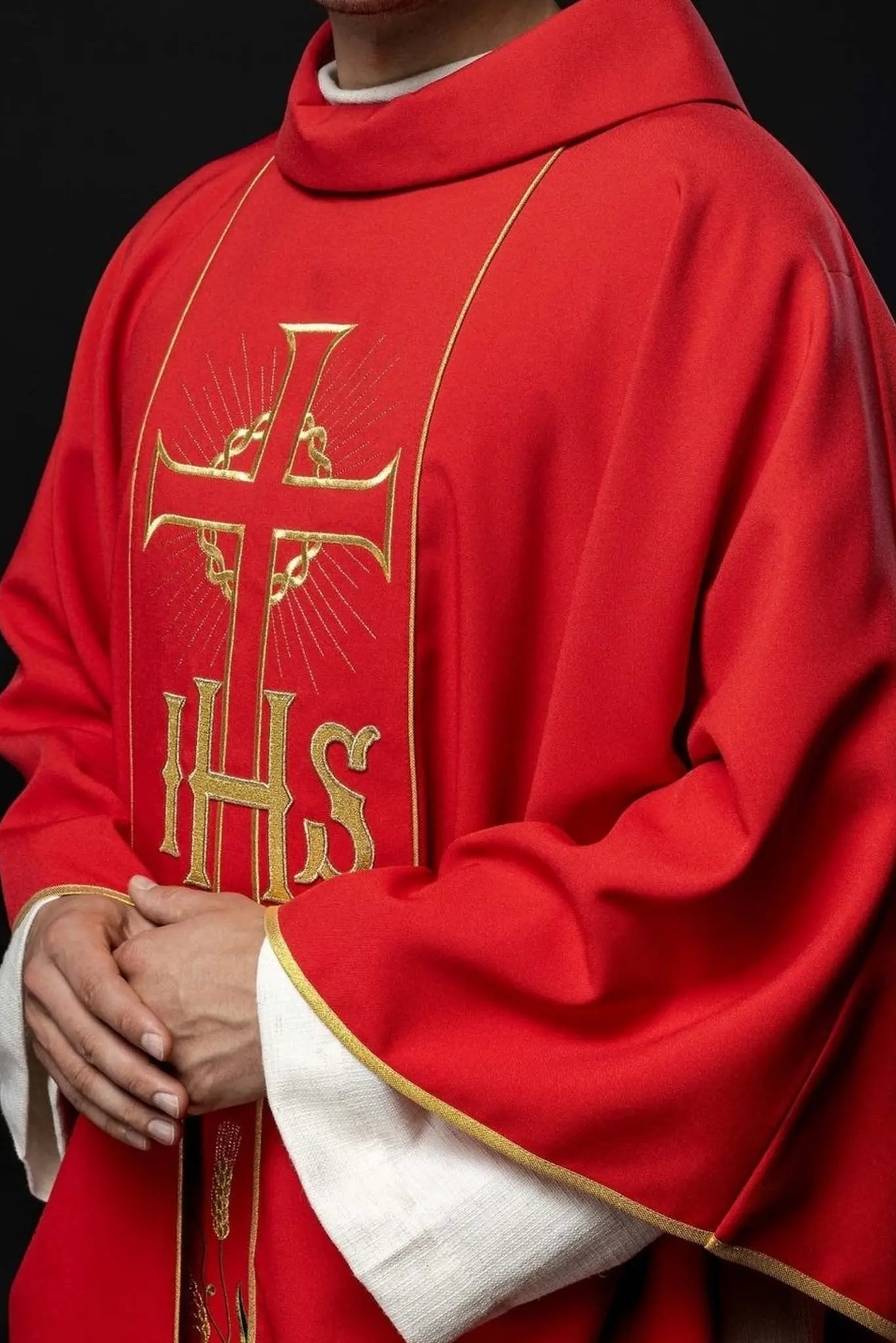 Casulla roja con cinturón dorado decorado con IHS y espigas