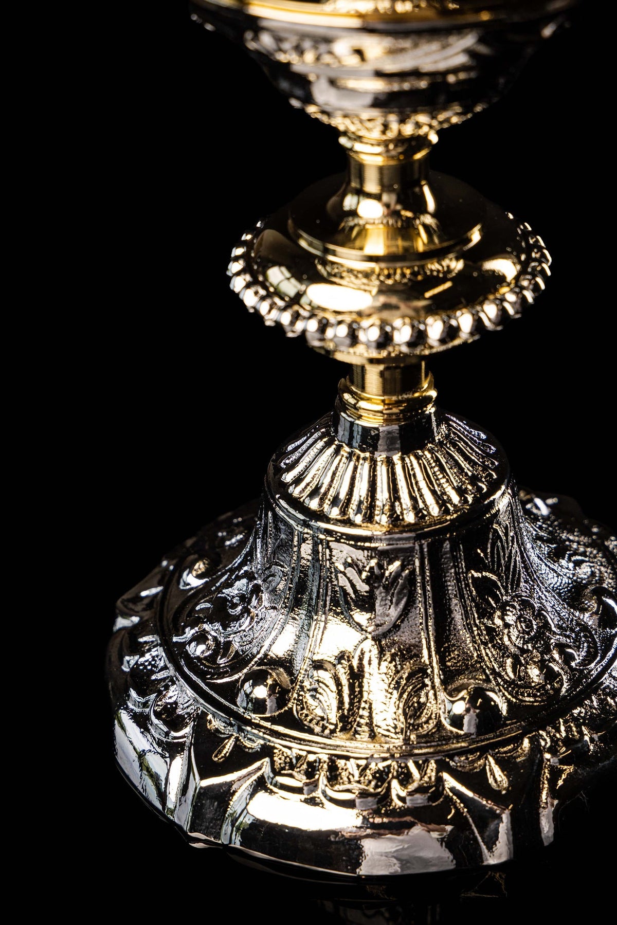 Gold and silver chalice with relief plant motifs, close-up of embossed base