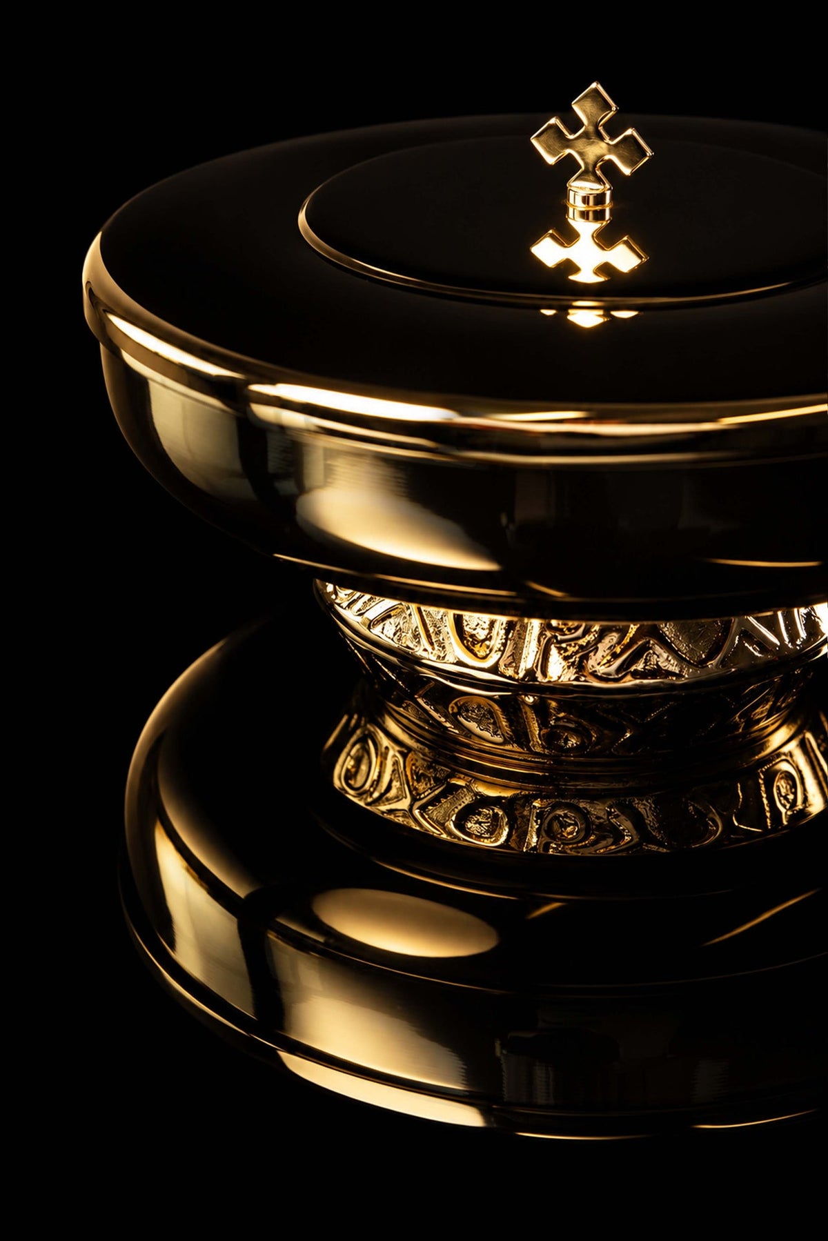 Gold-plated ciborium with decorative cross, close-up view of lid and ornate base