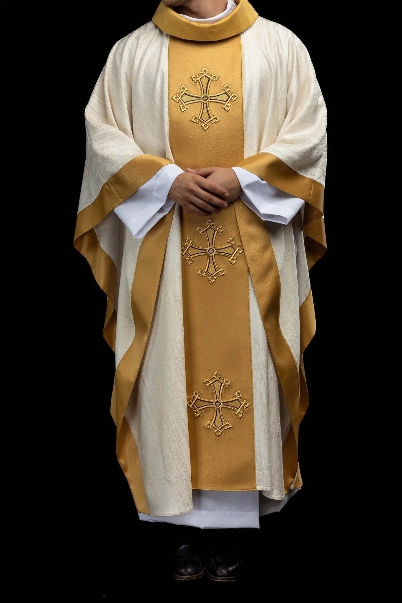 Ecru chasuble with embroidered cross motif and gold band on decorative fabric