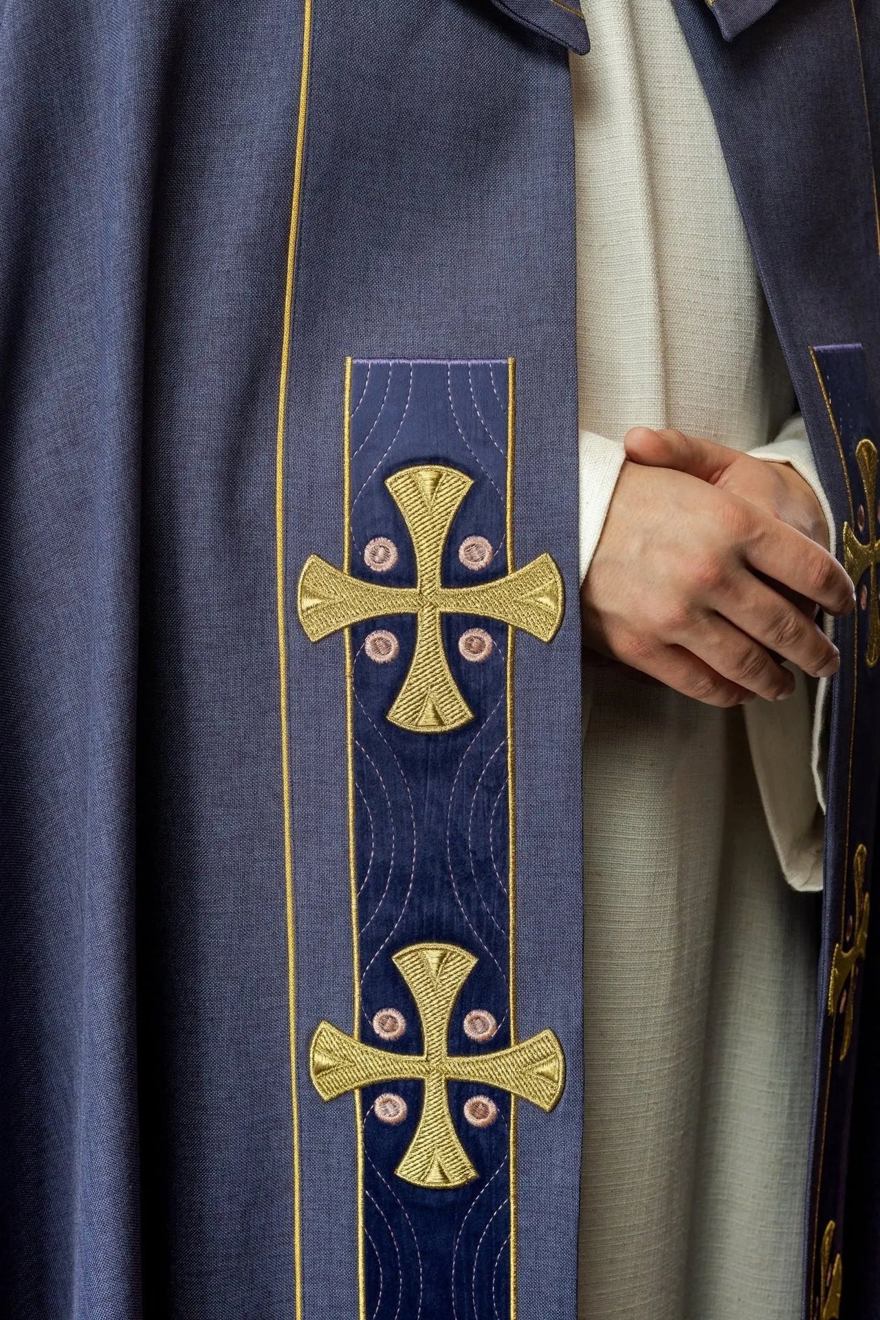 Capa litúrgica con cruces bordadas en oro y cuello de terciopelo púrpura